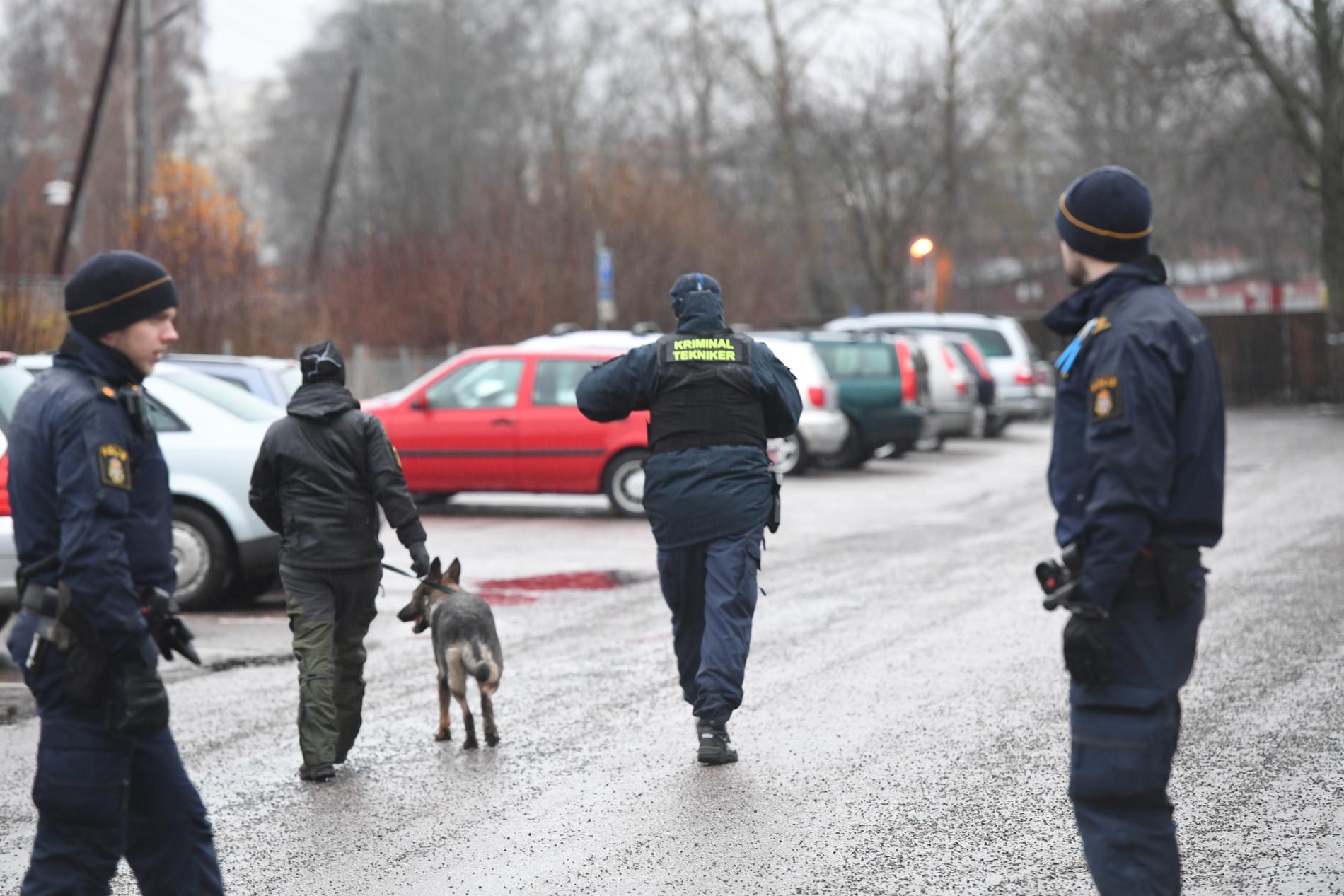Poliser söker igenom parkeringsplatsen i närheten av polishuset i Uppsala