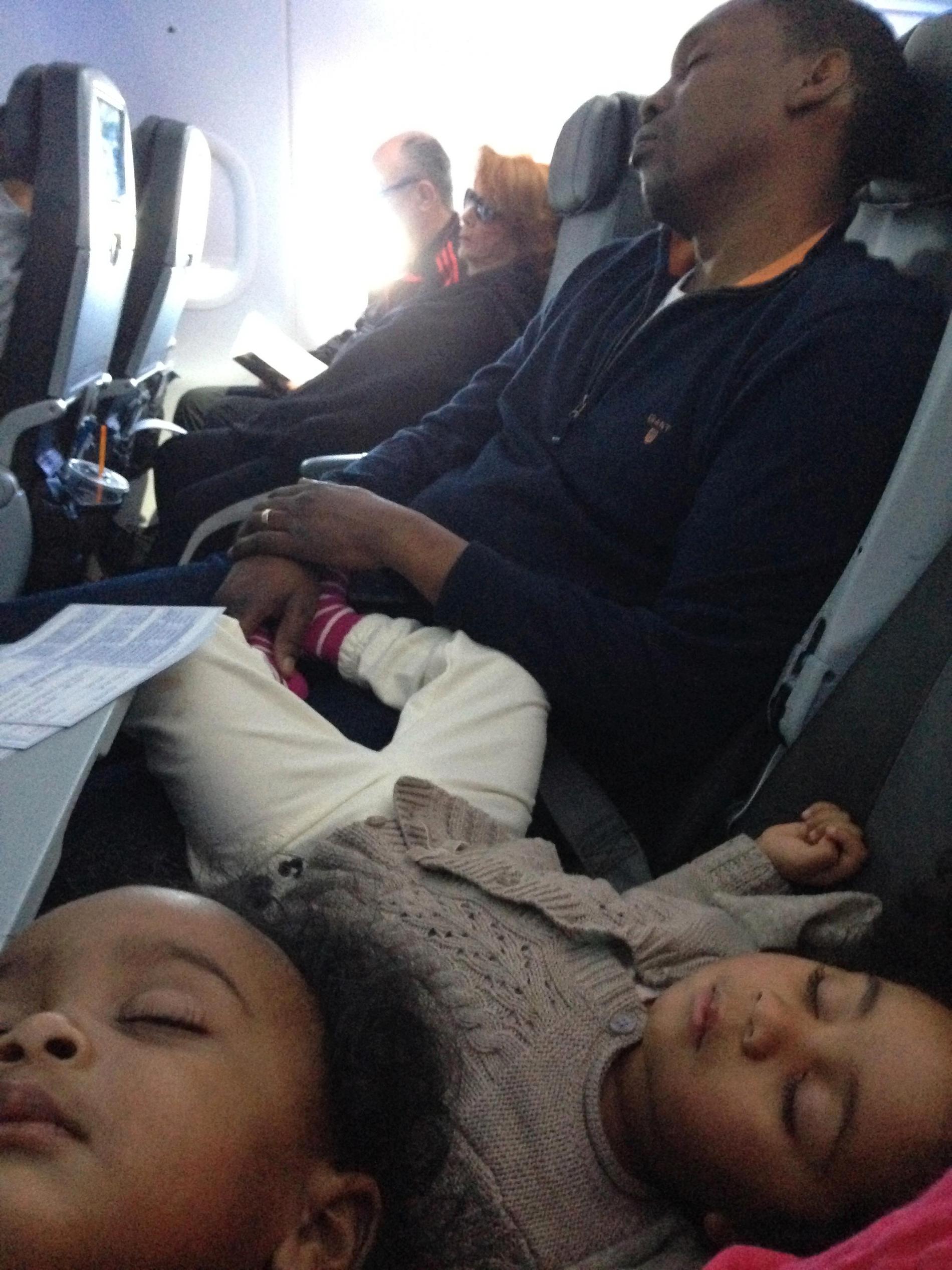 Pappa Foyd och barnen Céline och Olivia Jane sover gott på planet på väg till New York. 