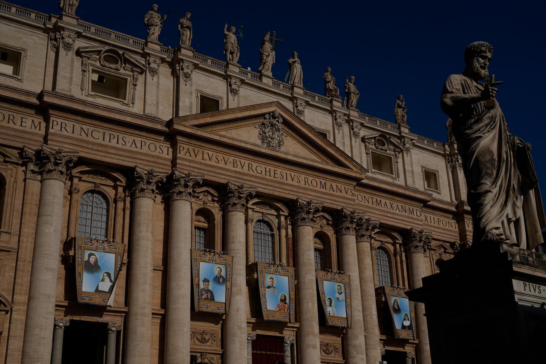 Gobelänger med porträtt av de nya helgonen har hängts upp på Peterskyrkan i Vatikanstaten.