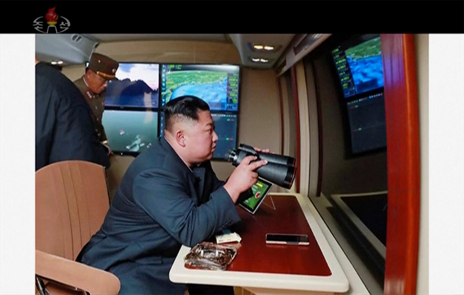 Nordkoreas diktator Kim Jong-Un under en av de tidigare robotuppskjutningarna. Skärmdump från nordkoreansk tv.
