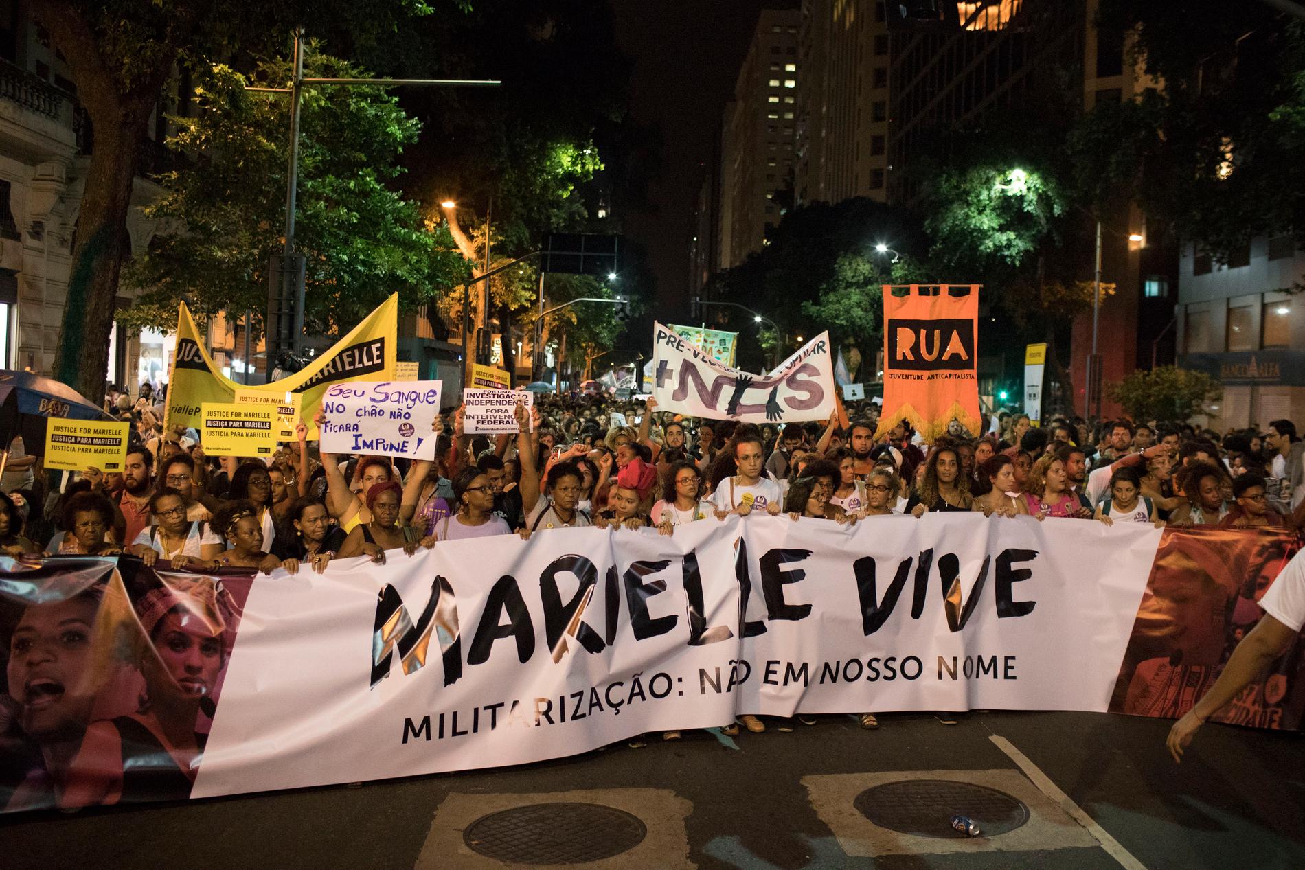 Demonstranter håller flaggor med budskapet "Marielle lever" under en demonstration i Rio några dagar efter mordet i mars 2018.