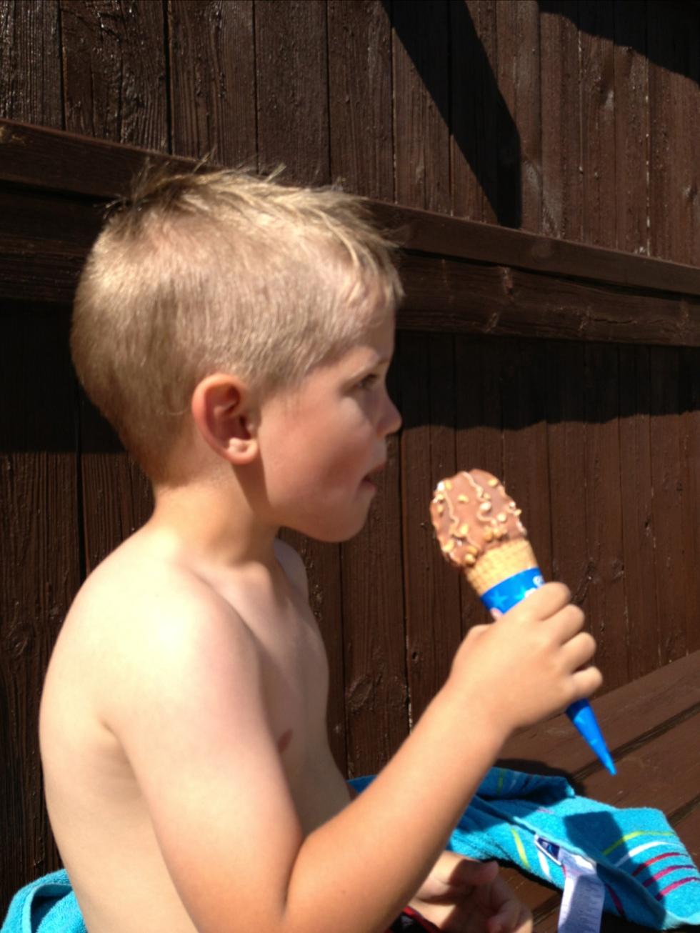 Yngsta sonen äter en glass i sommarvärmen.