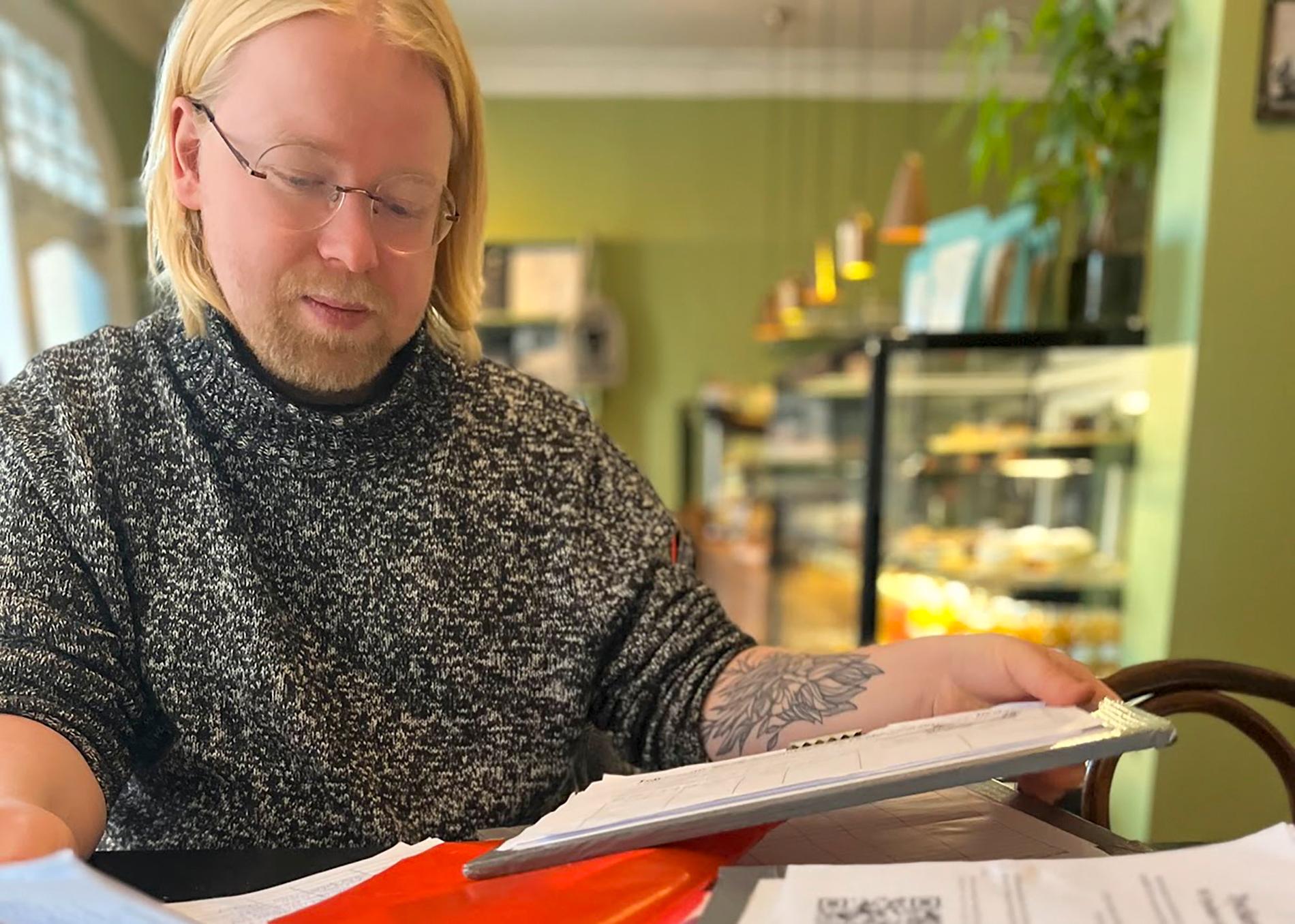 Oliwer Schultz går igenom listorna med namnunderskrifter som samlats in för att få till en folkomröstning om utförsäljningen av det kommunala konserthuset Louis de Geer i Norrköping. Pressbild.