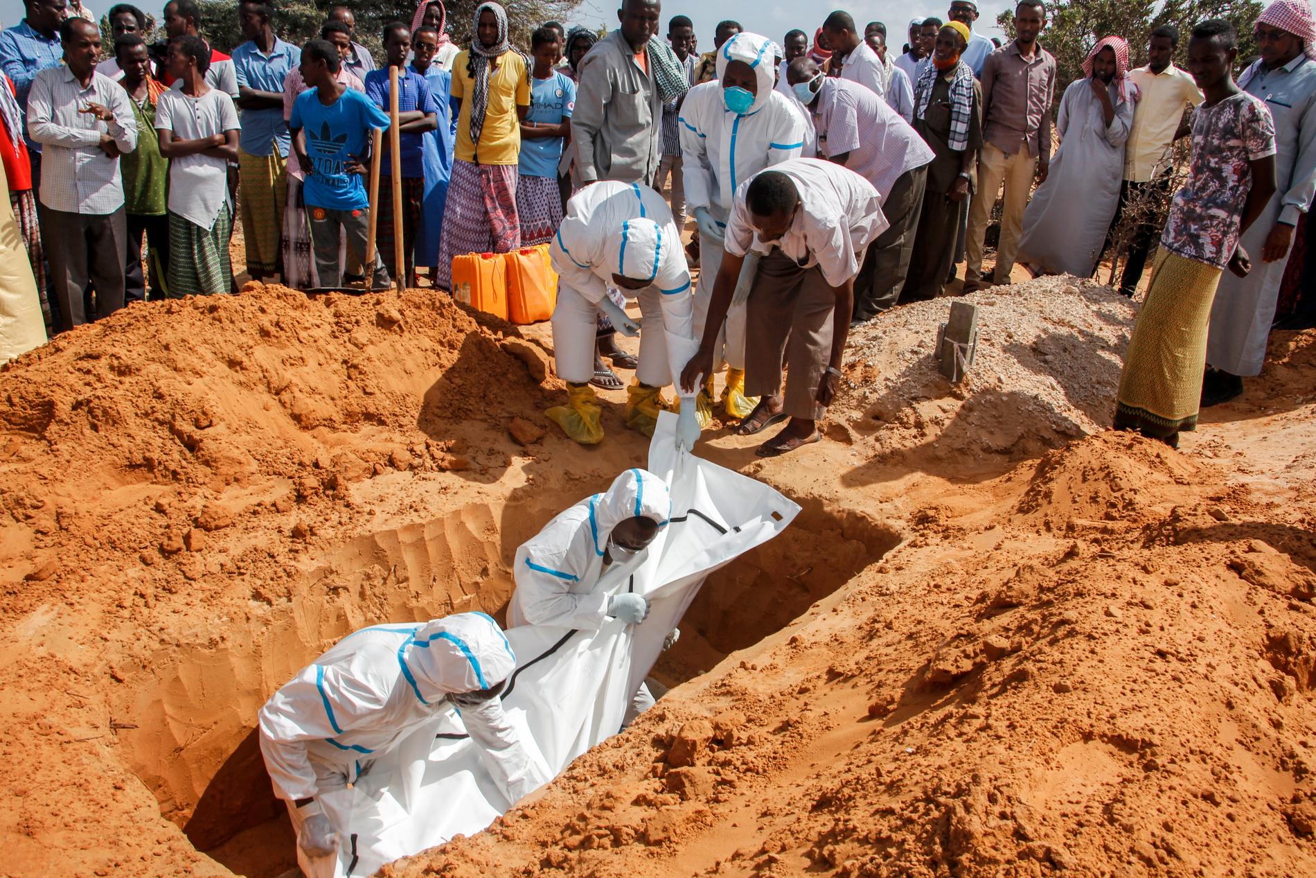 Vårdpersonal i skyddsutrustning vid en begravning av en man som dött i covid-19 på en begravningsplats i Somalias huvudstad Mogadishu.