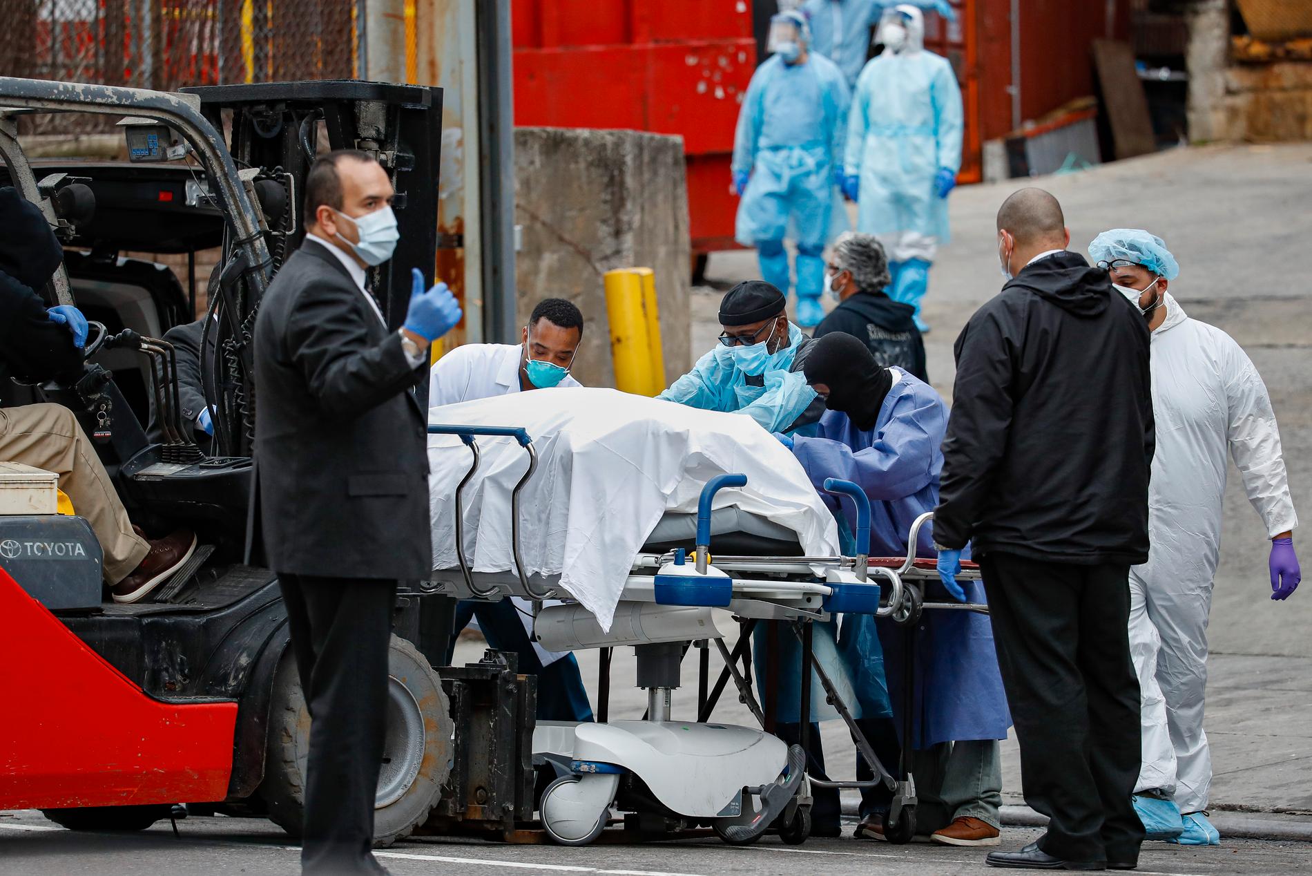 New York har drabbats hårt av coronaviruset. Här syns vårdpersonal hjälpa till att transporta en avliden person från Brooklyn Hospital Center. 