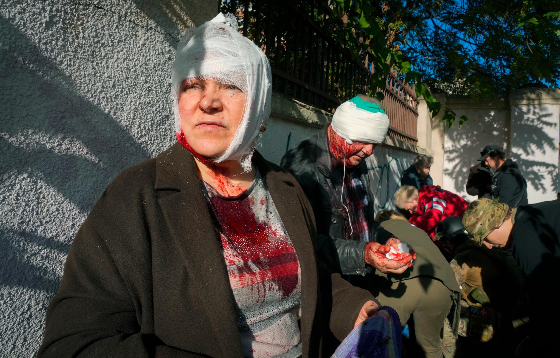 Skadade civila får behandling av sjukvårdspersonal efter explosionerna i Kiev på måndagsmorgonen.