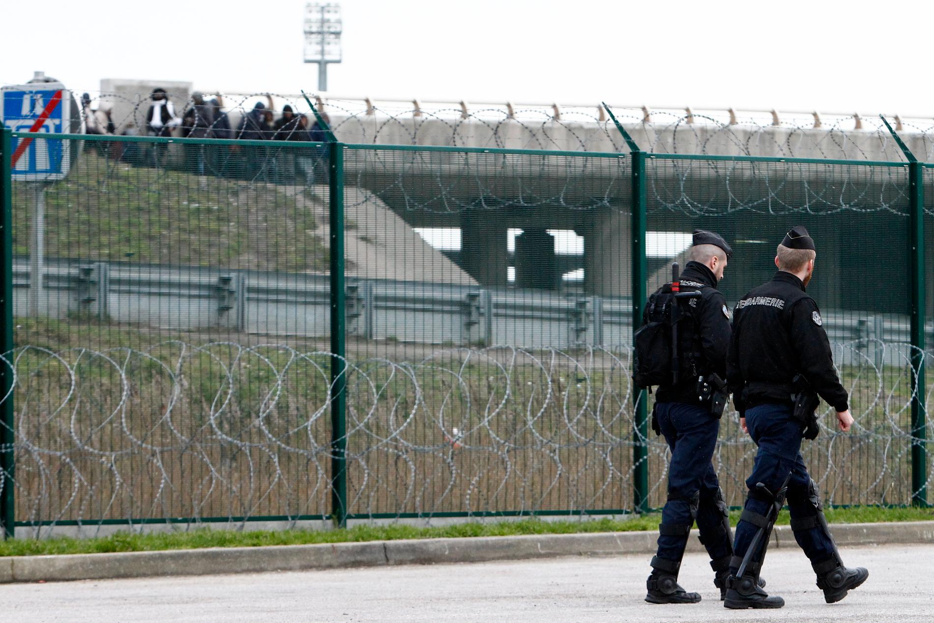 Två franska poliser patrullerar vägen som leder till hamnen i Calais. Arkivbild från 2018.