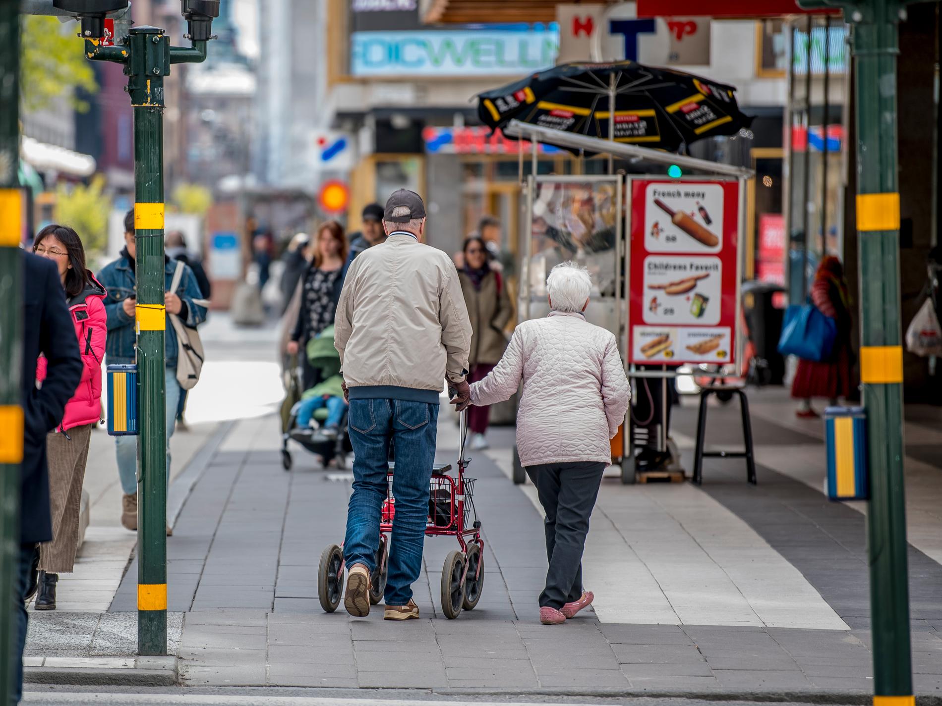 Ett äldre par på promenad i Stockholm under Valborgsmässoafton. 