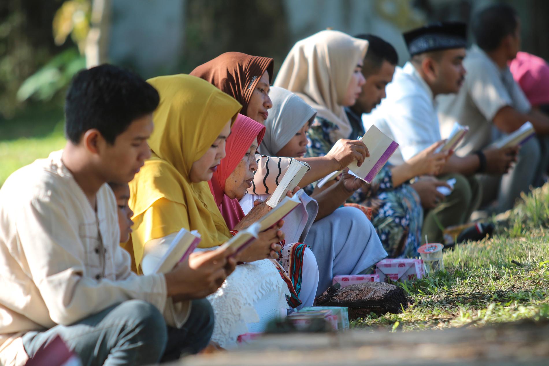 Sörjande ber vid en gravplats för tsunamioffren i Banda Aceh i Indonesien under torsdagen.