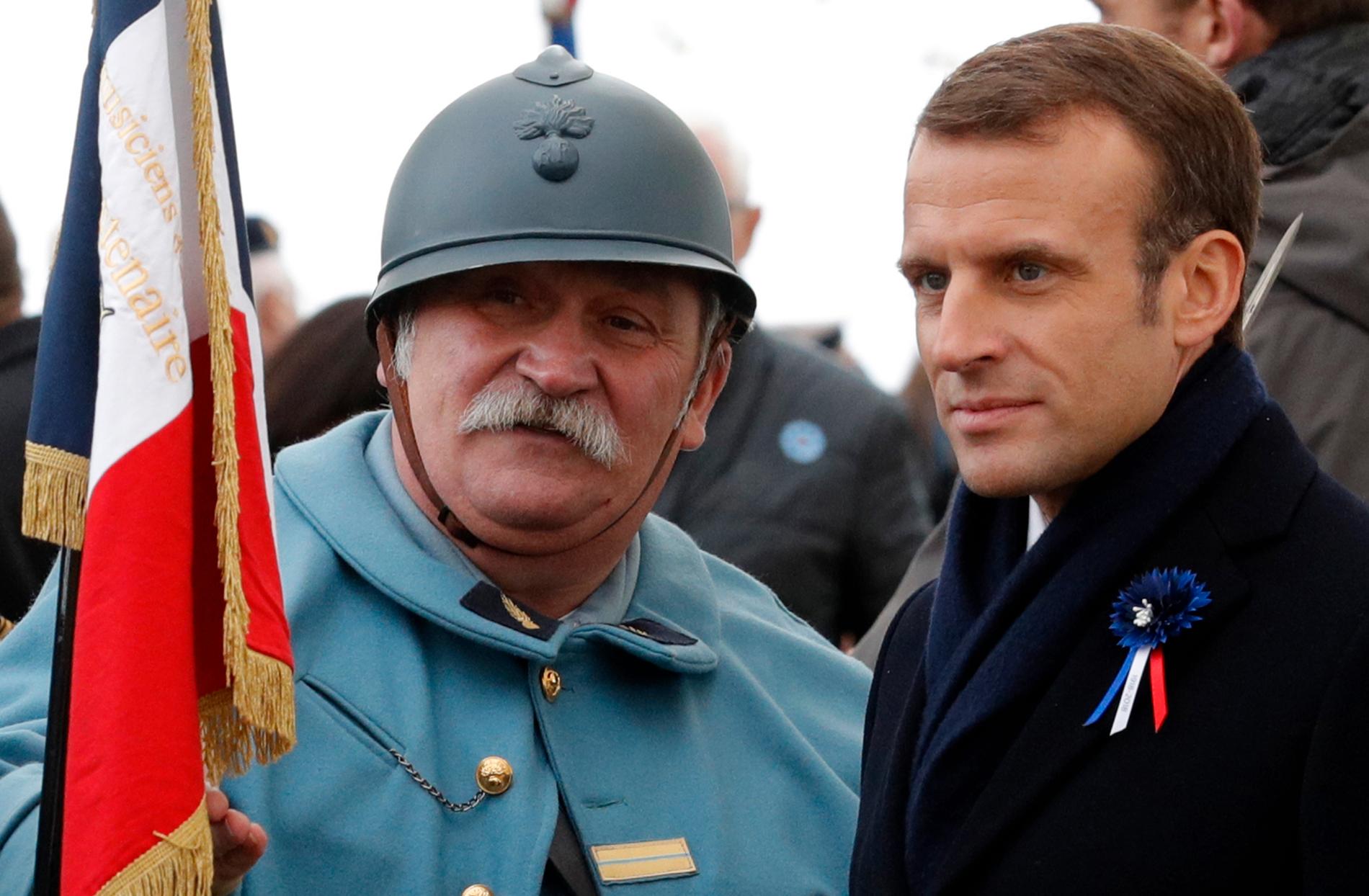 Frankrikes president Emmanuel Macron (till höger) tillsammans med en soldat i tidstypisk klädsel vid en ceremoni i Morhange till minnet av första världskrigets slut 1918.