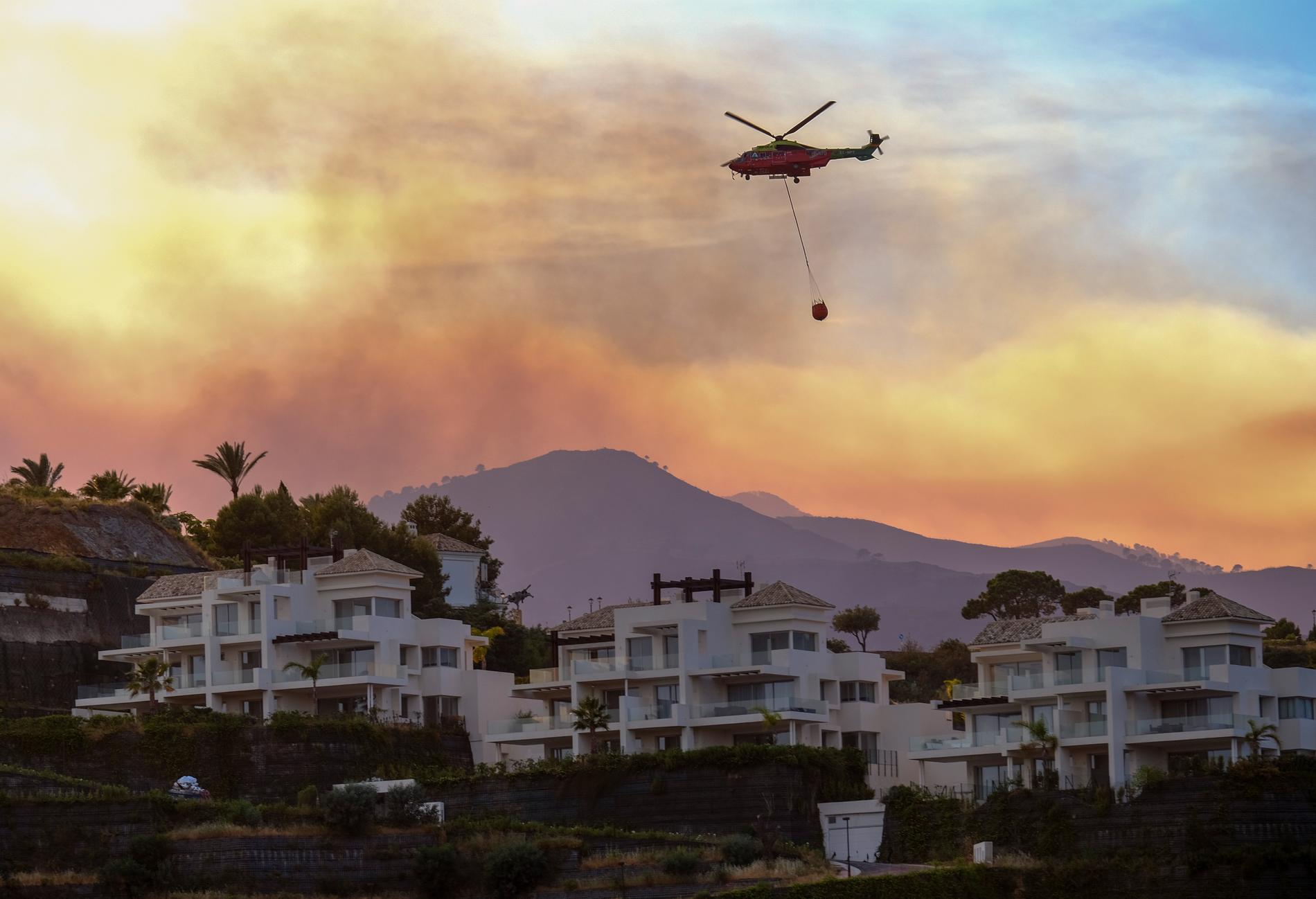 Helikoptrar bekämpar skogsbränder under värmeböljan i Andalusien.