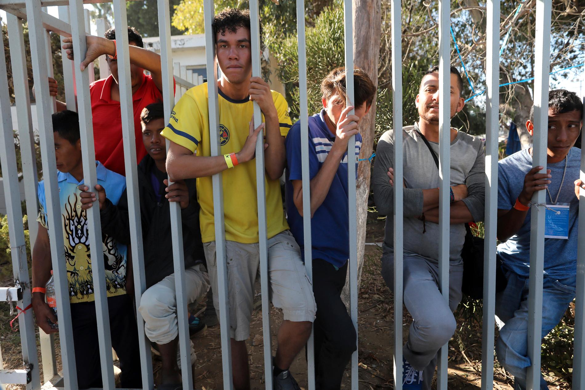 Centralamerikanska migranter bakom staketet till ett tillfälligt boende i Tijuana i Mexiko.