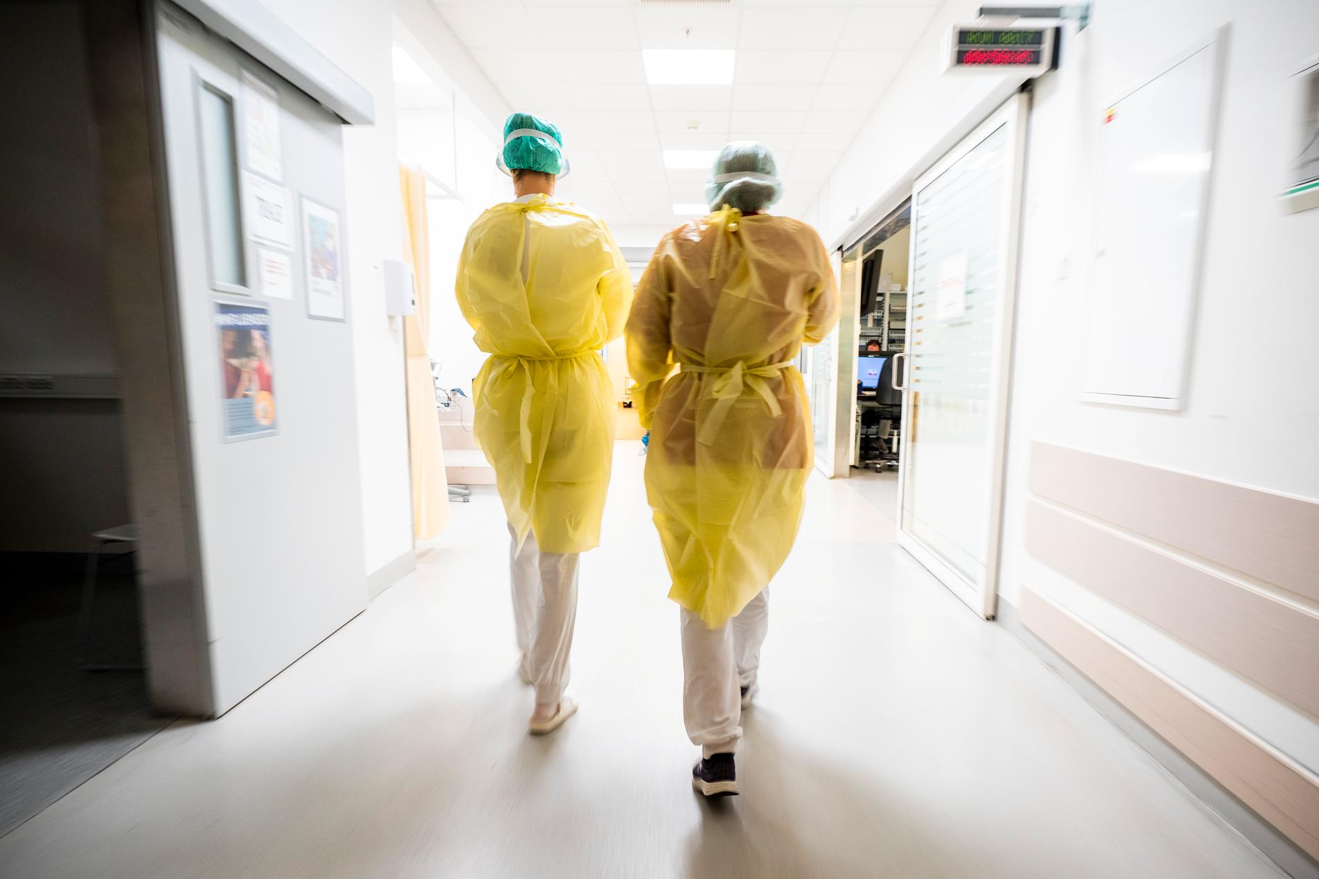 Sjukhuspersonal i skyddutrustning på väg att ta hand om en patient med covidsymtom på akutmottagningen på Ahus på Lørenskog i Viken.
