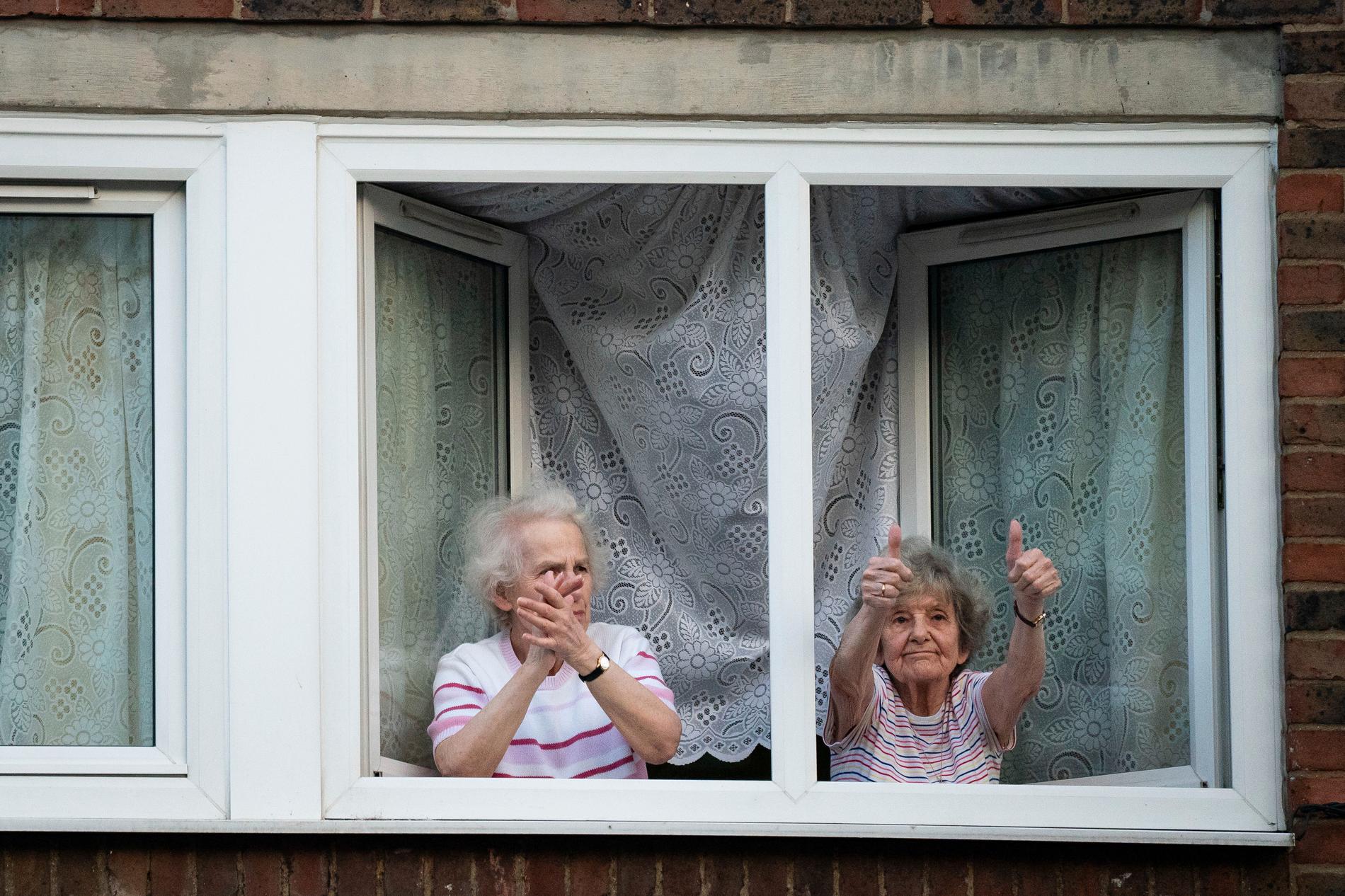 Två av de miljontals Londonbor som den senaste tiden varit begränsade till sina hem gör tummen upp för landets sjukvårdsservice NHS. Bilden från i början av maj.