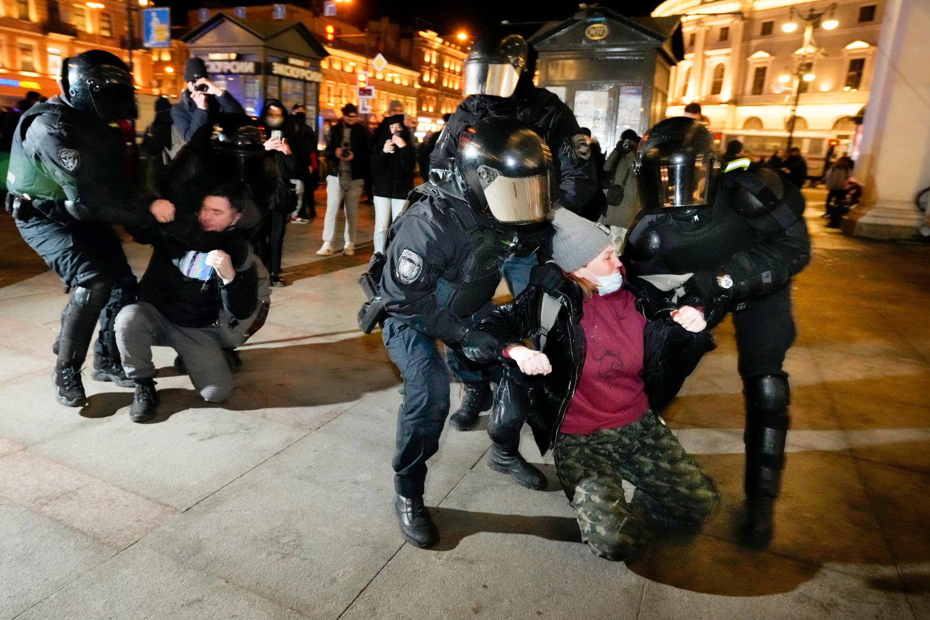 Antikrigsdemonstranter grips av polis i St Petersburg.