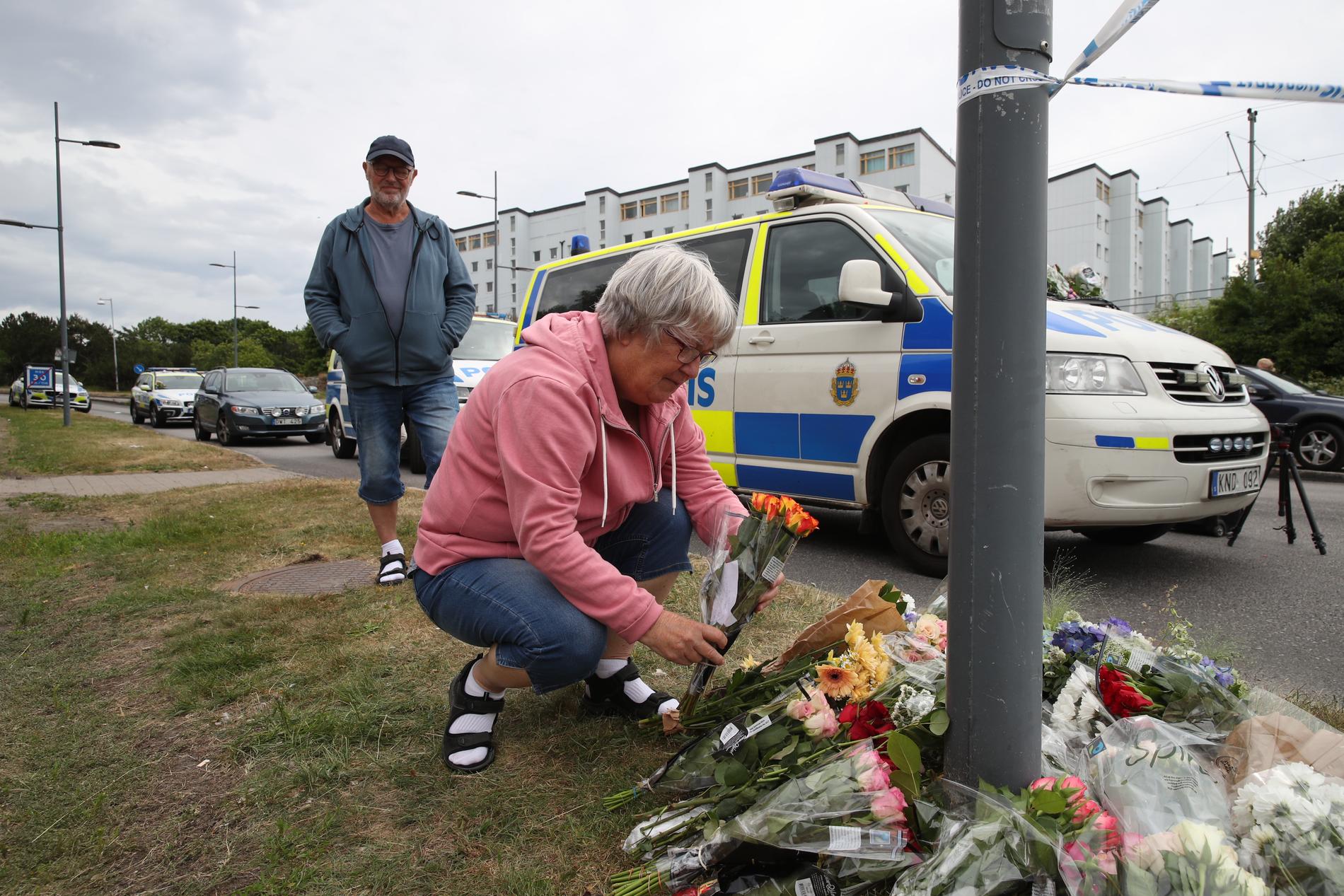 Boende i området lägger blommor på platsen där polismannen sköts.