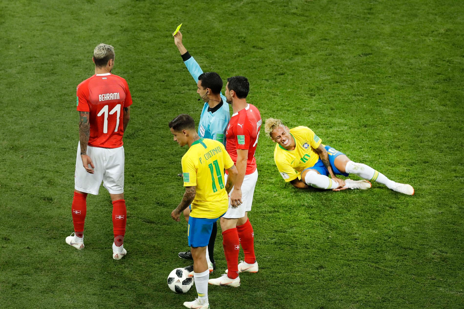 Valon Behrami får gult kort medan Neymar har ont i matchen mellan Schweiz och Brasilien i fotbolls-VM 2018.