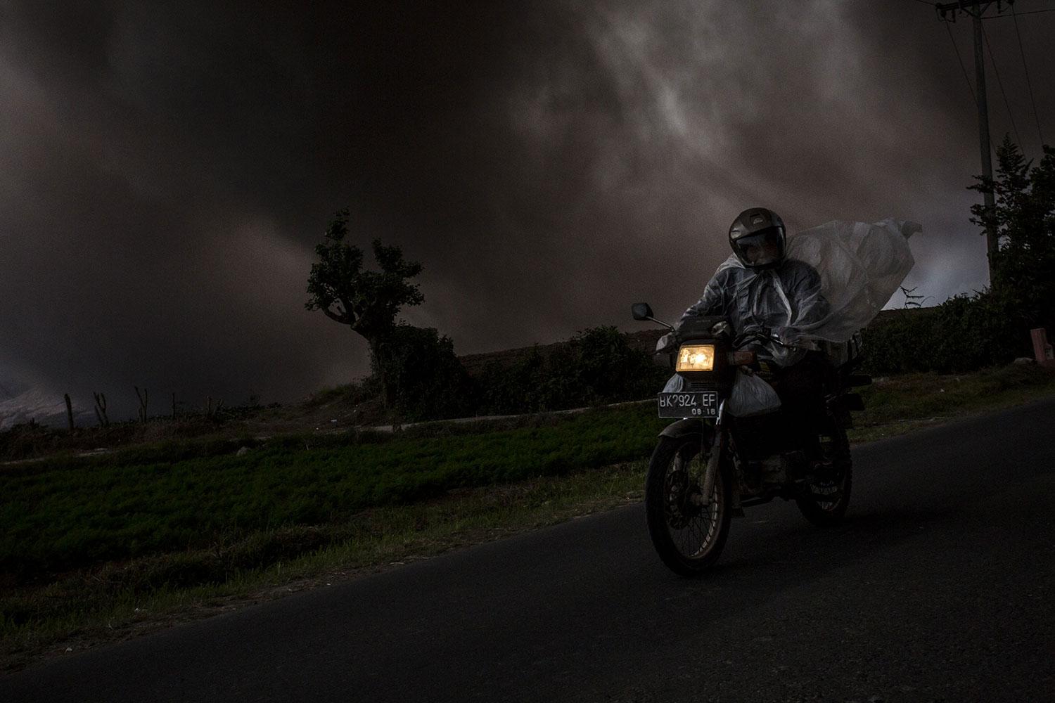 En man kör motorcykel genom tjock rök.
