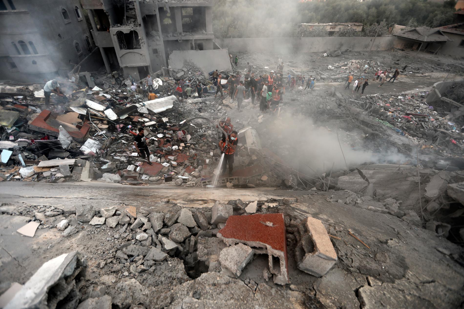 Palestinier letar efter överlevande i ruinerna efter ett flyganfall.