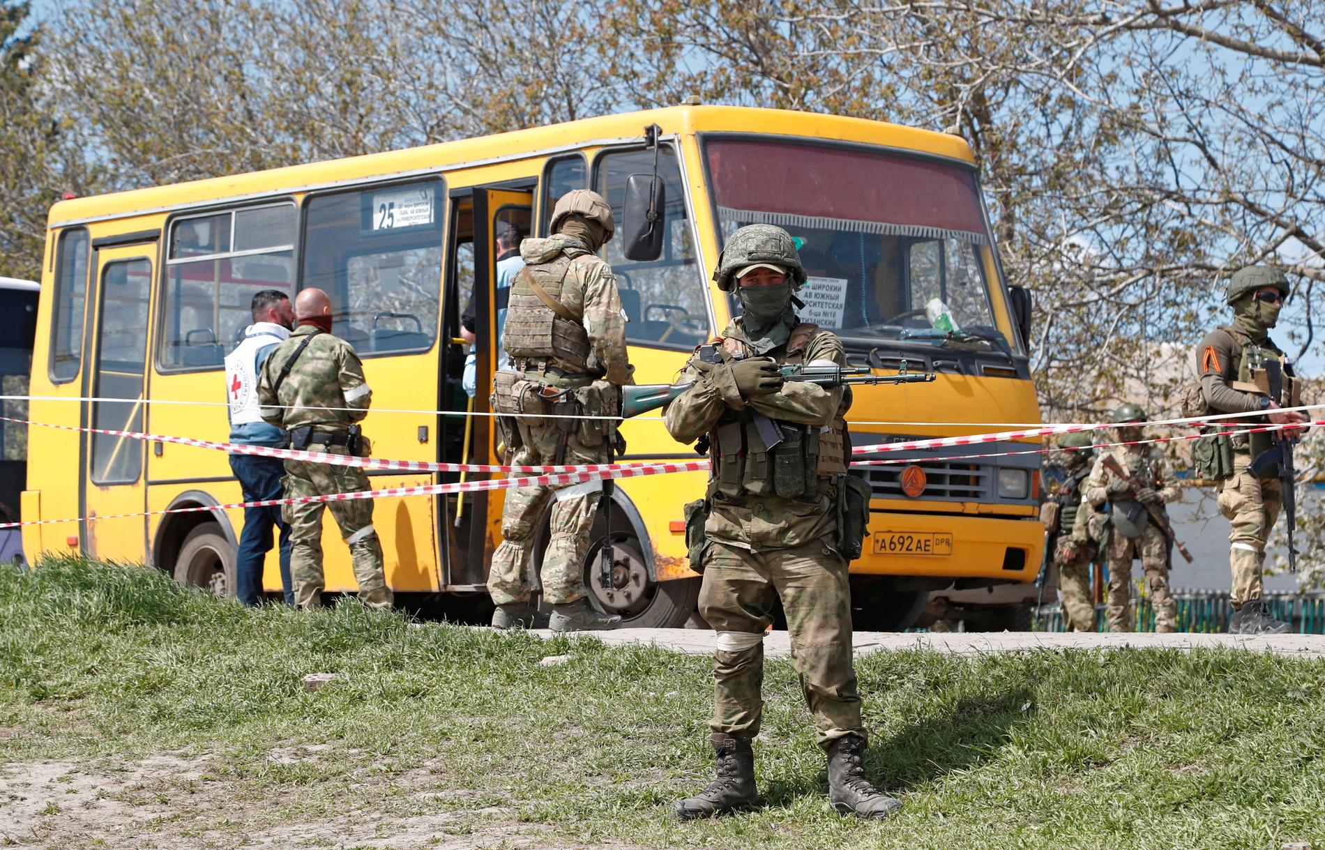 Pro-ryska soldater är på plats vid mottagningscentret dit evakueringsbussarna anlänt.