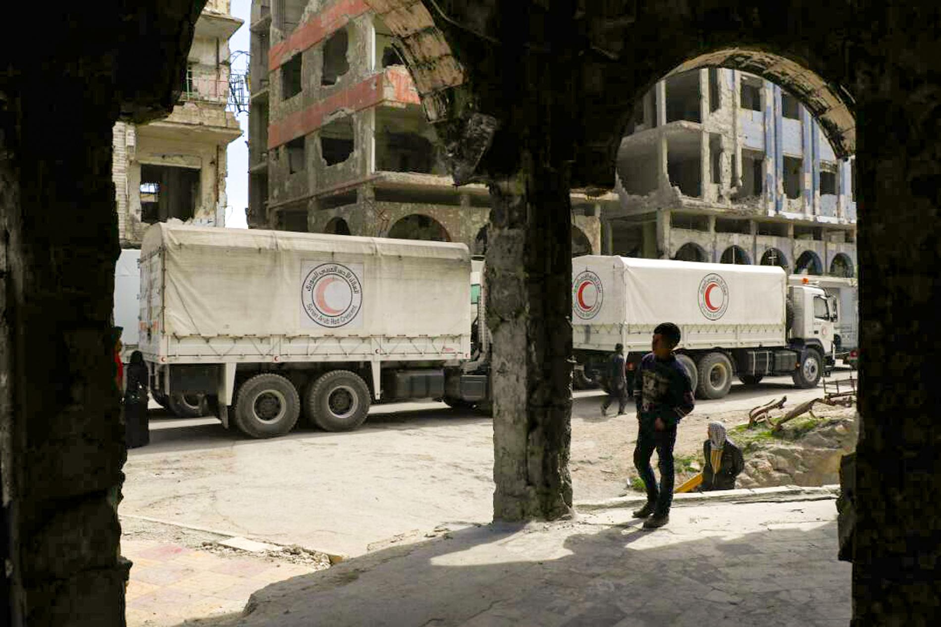 Lastbilar från syriska Röda halvmånen i den krigshärjade syriska staden Douma, nära huvudstaden Damaskus. 80 procent av Syriens befolkning lever i fattigdom, slår en rapport från Oxfam fast. Arkivbild.