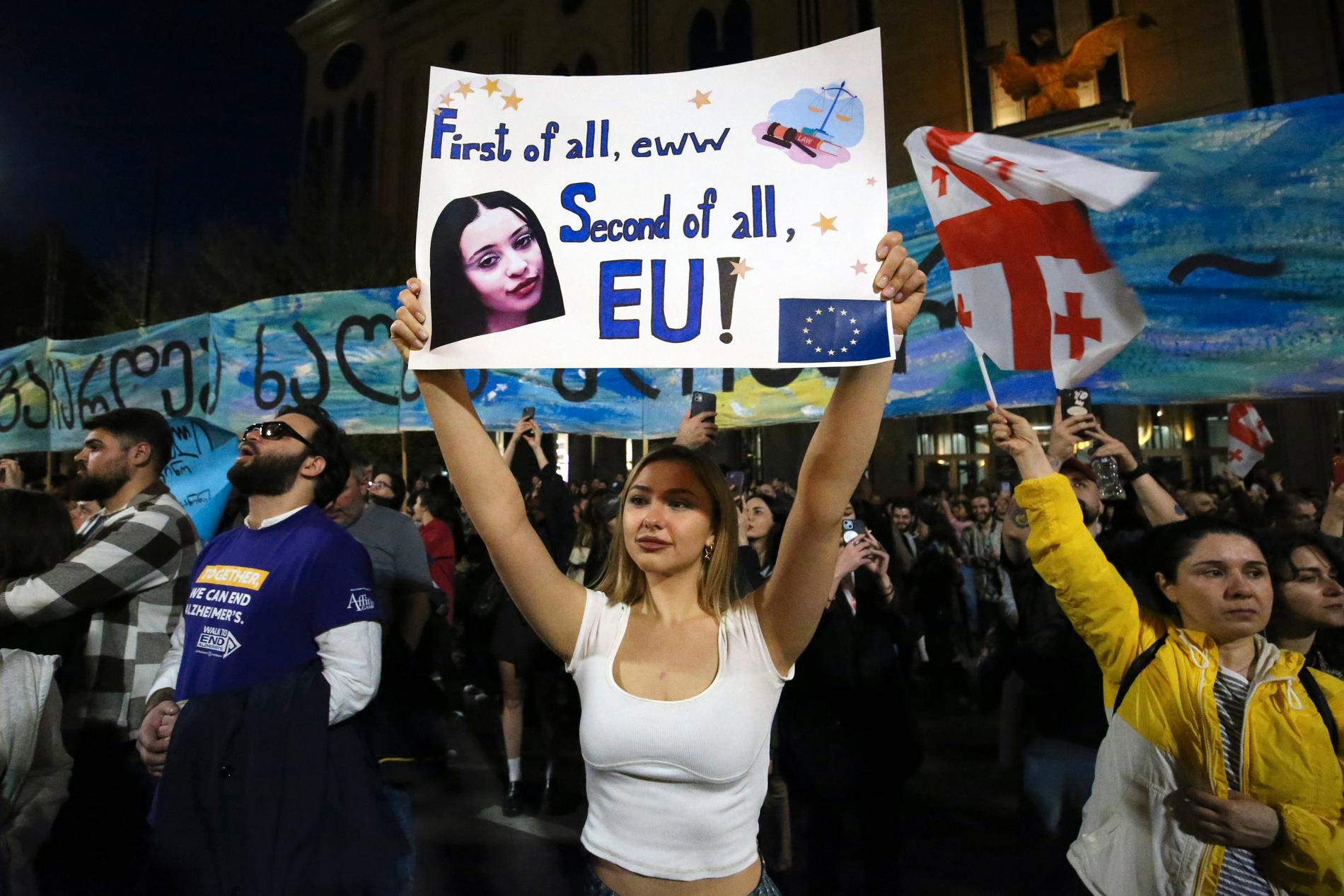 En demonstrant håller upp en skylt med ett EU-vänligt budskap i Tbilisi på tisdagen.