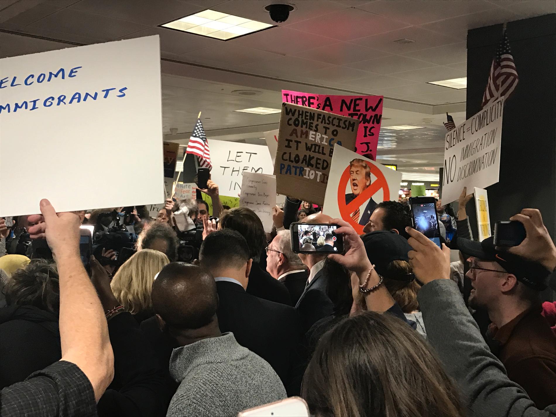 Många av aktivisterna har skyltar med Trump-kritiska budskap och uppmaningar till solidaritet. Talkörer om öppna gränser ekar mellan väggarna.