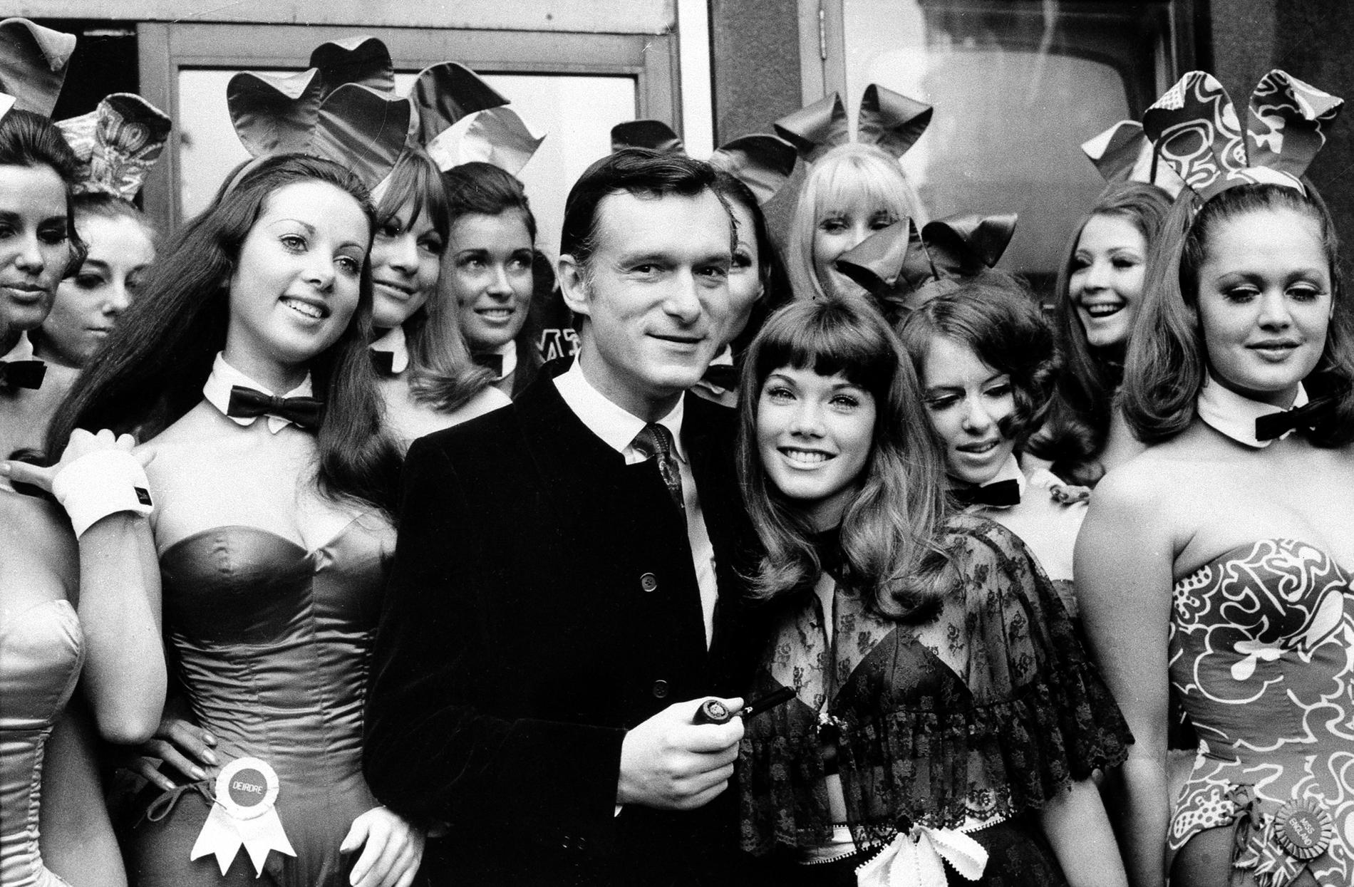 Hefner tillsammans med Barbara Benton, omsvärmade av ”Bunny girls” på Playboysklubben i London. 1969.