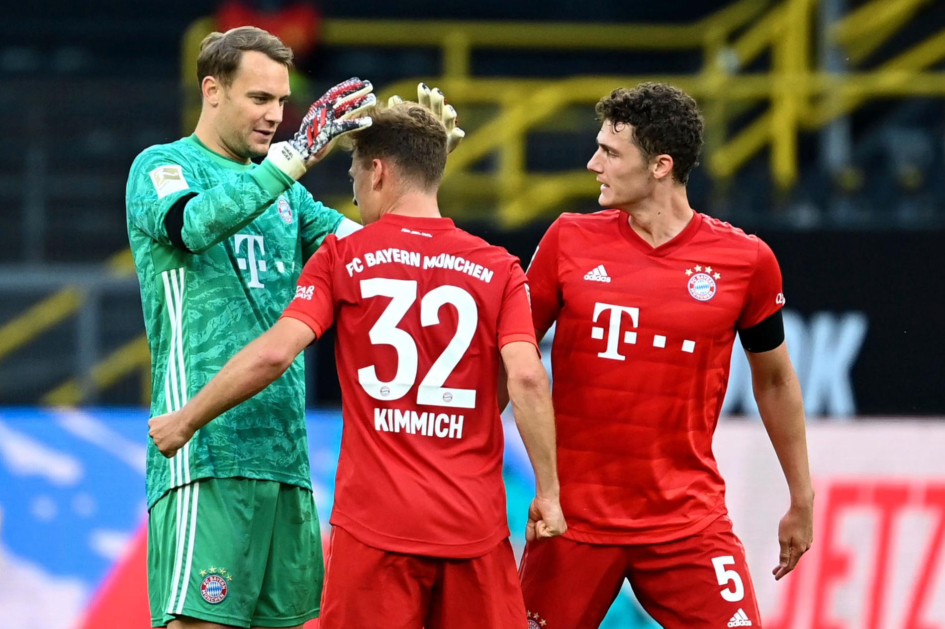 Bayern Münchens Joshua Kimmich, mitten, kramas om efter att lobbat in segermålet borta mot Dortmund.