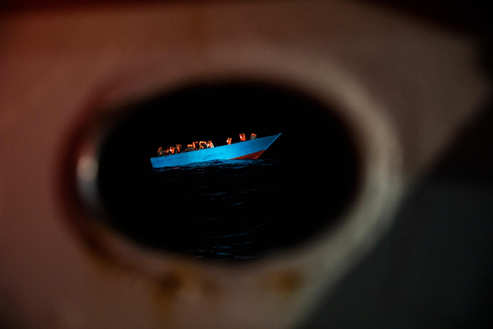 Migranter på en enkel båt i Medelhavet väntar på räddning i september i år.