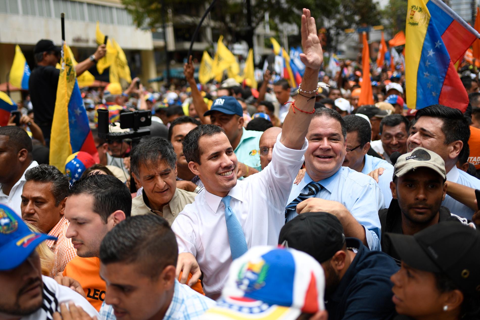 Oppositionsledaren Juan Guaidó (i mitten) omgiven av anhängare i en protestmarsch i Venezuelas huvudstad Caracas på tisdagen.