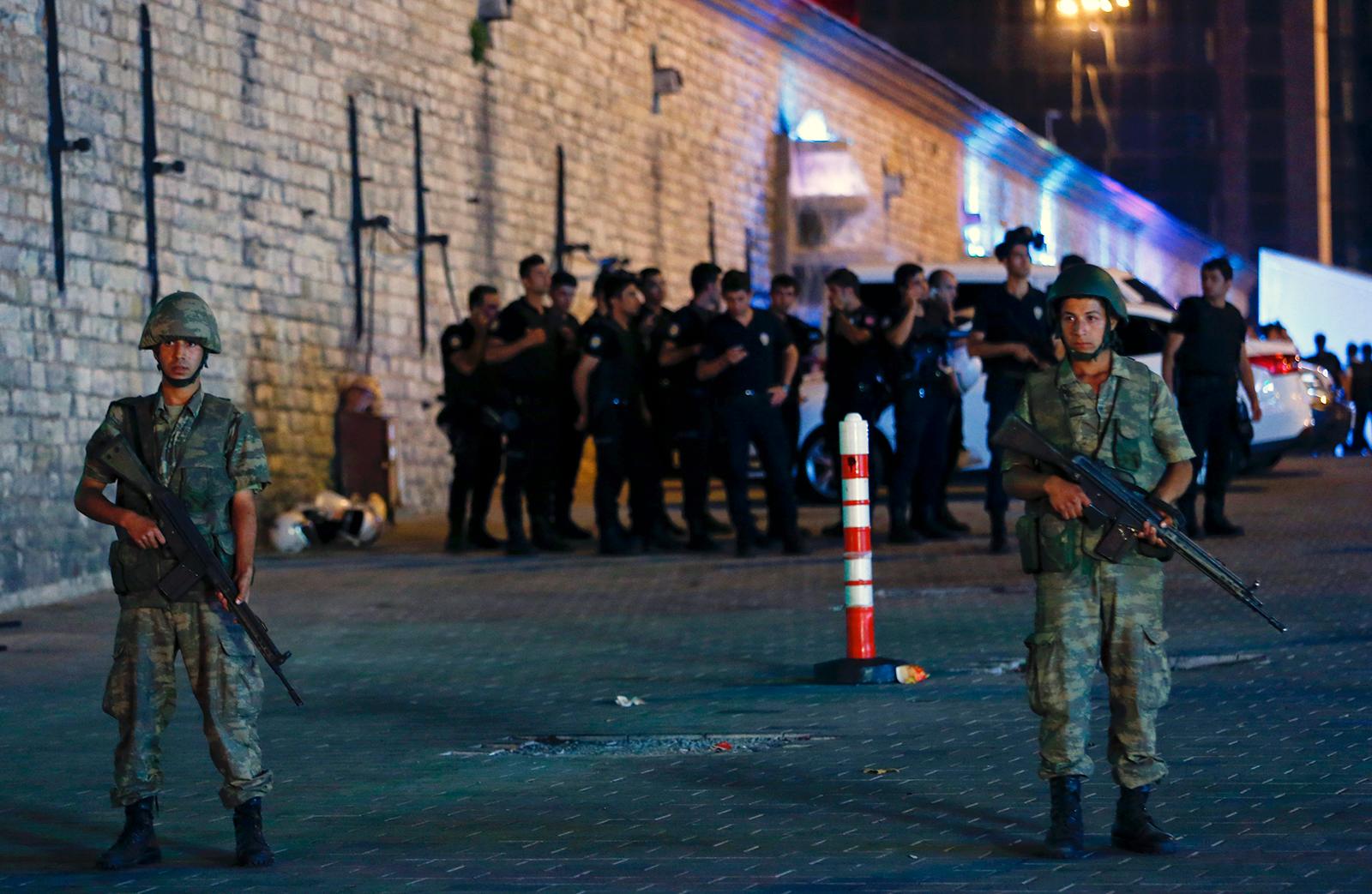 Militär står vakt vid Taksimtorget i Istanbul, ett stort antal poliser hålls innanför avspärrningarna av oklar anledning.