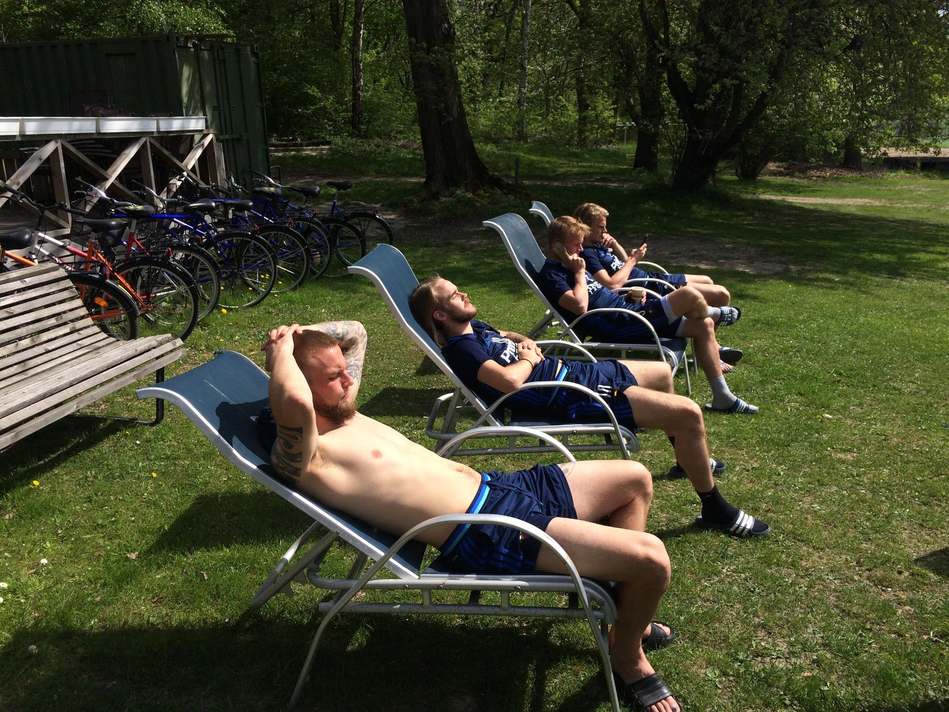 Några spelare i Djurgården tar det lugnt i solen i samband med torsdagens träning.