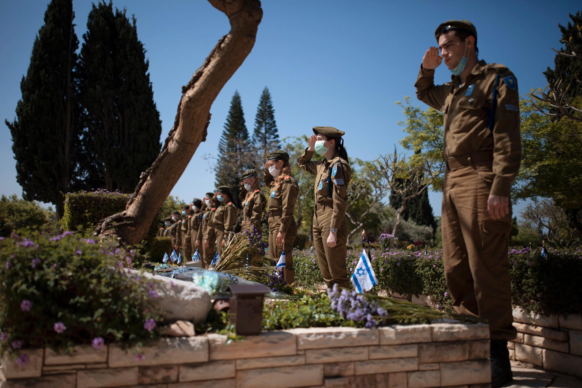 Israelisk militär bär munskydd under måndagens minneshögtid för stupade soldater i Tel Aviv.