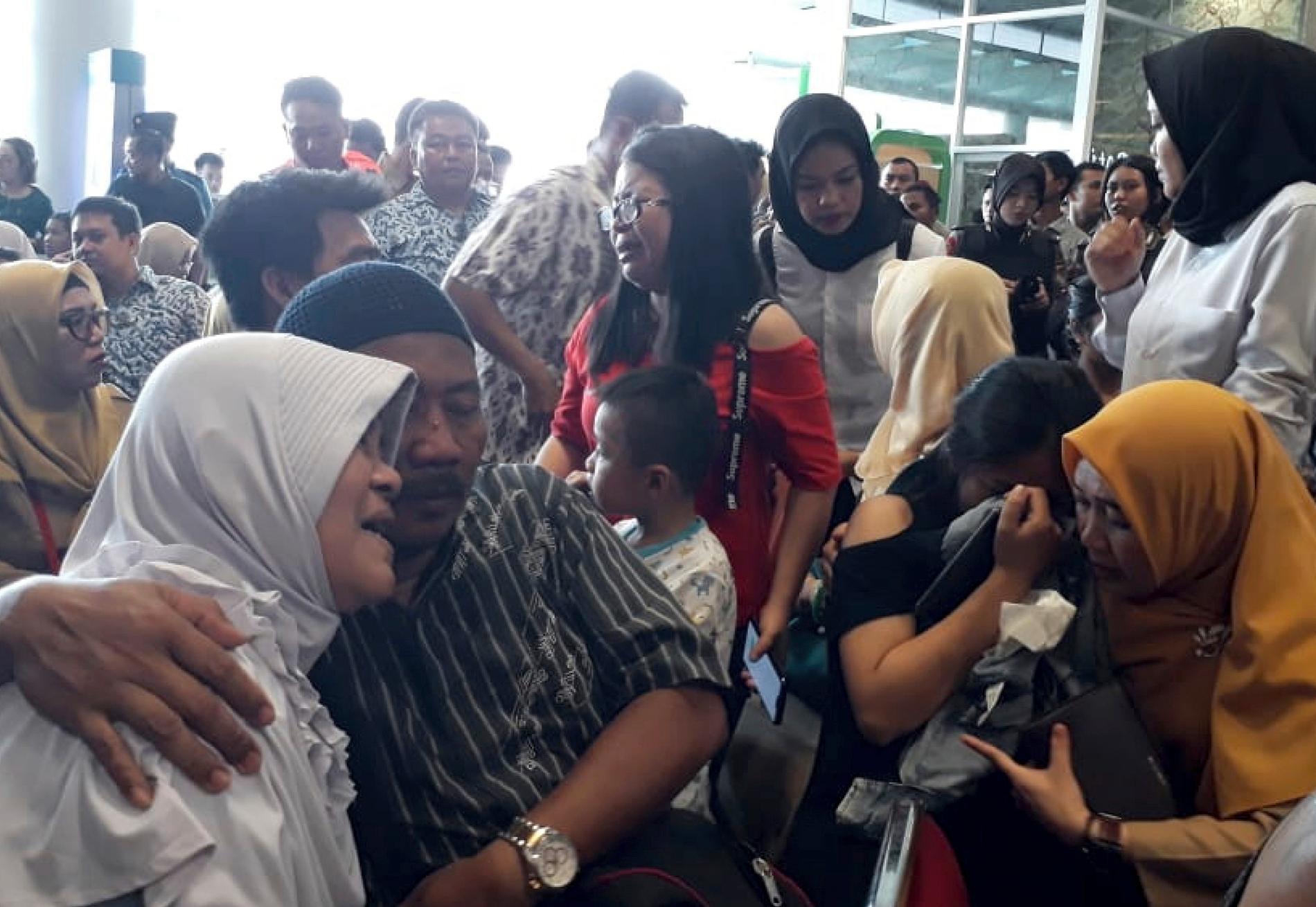 Anhöriga till personer ombord på flygplanet samlas på flygplatsen i Pangkal Pinang i väntan på nyheter.