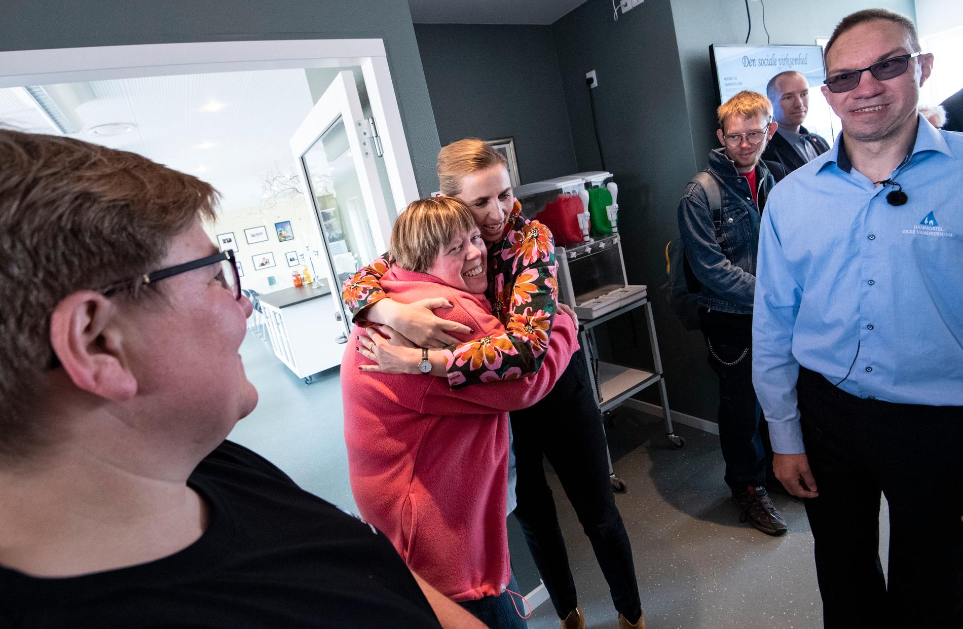 Många vill få en kram av Mette Frederiksen, socialdemokratisk partiledare i Danmark, när hon besöker vandrarhemmet i Faxe, som har profilerat sig som en arbetsplats för arbetshandikappade.