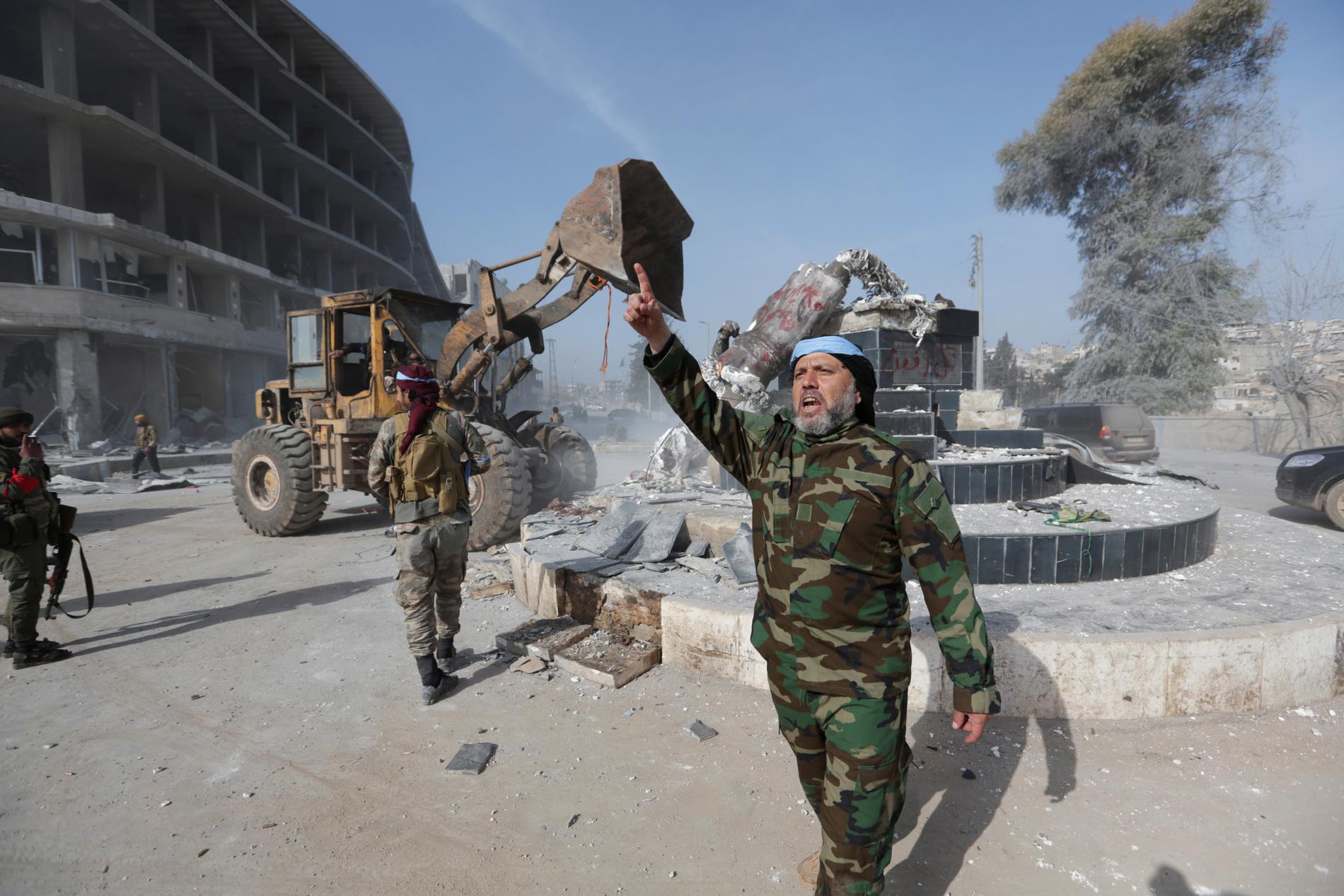 Turkiskstödda styrkor tar ner en kurdisk staty i Afrin.