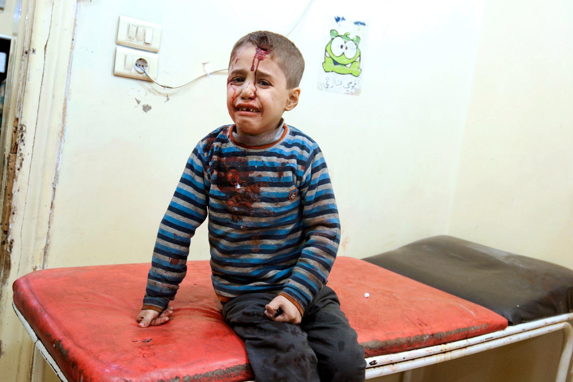 En skadad pojke tas omhand i ett provisoriskt sjukhus i Aleppo efter de senaste dagarnas bombningar.