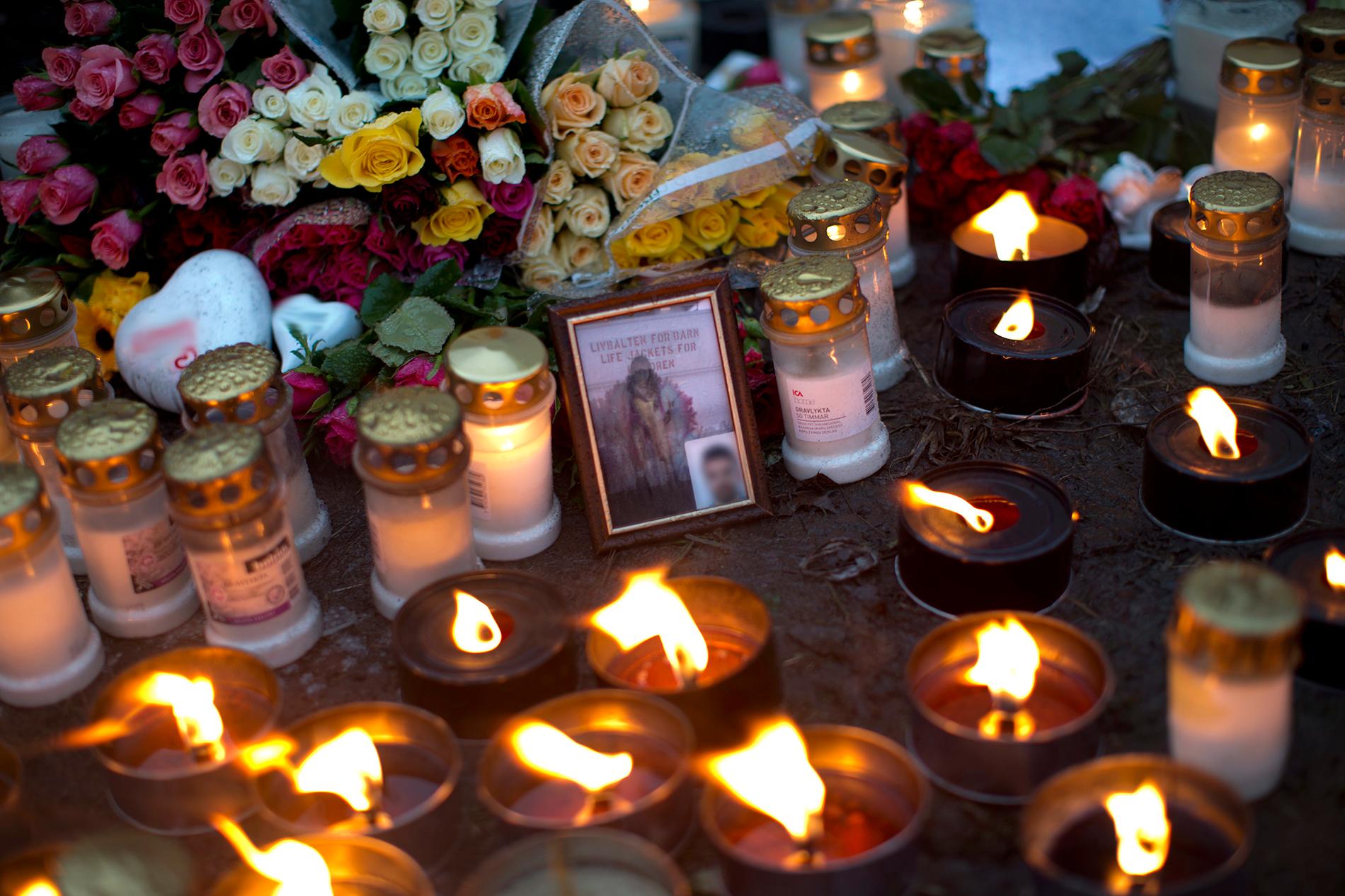 En stor mängd blommor och ljus på platsen i Uddevalla där tre personer hittades skjutna till döds.