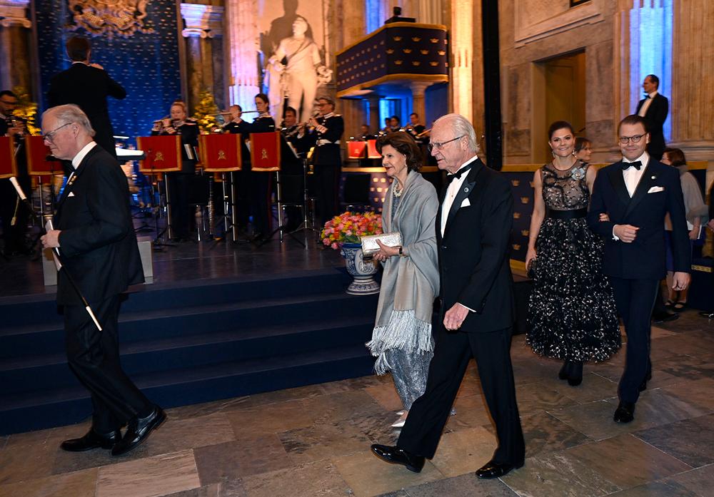 Kungaparet, kronprinsessparet och prinsparet tågar in i Rikssalen för musikunderhållning innan det är dags att sätta sig till bords för Sverigemiddagen på Kungliga slottet. 