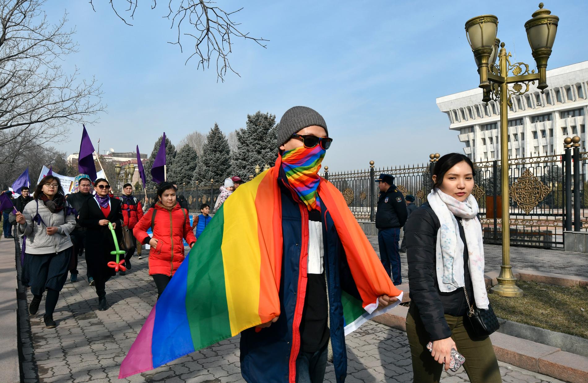 Människor marscherar förbi parlamentsbyggnaden i centrala Bisjkek i Kirgizistan på internationella kvinnodagen den 8 mars.