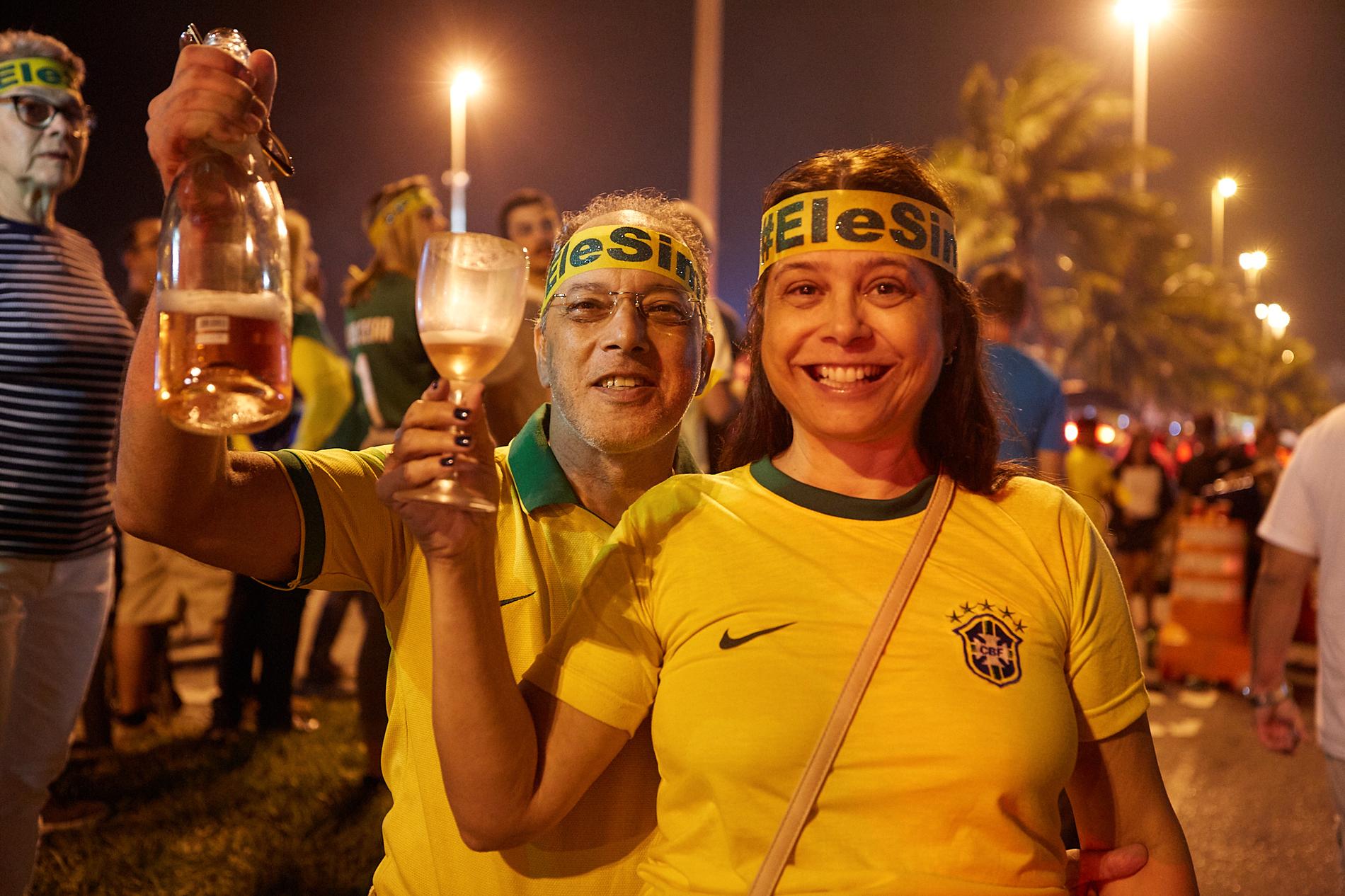 Celia Maria Barreto, 56  och hennes Marcos Rodrigues, 55, skålar i bubbel efter Bolsonaros vinst. 