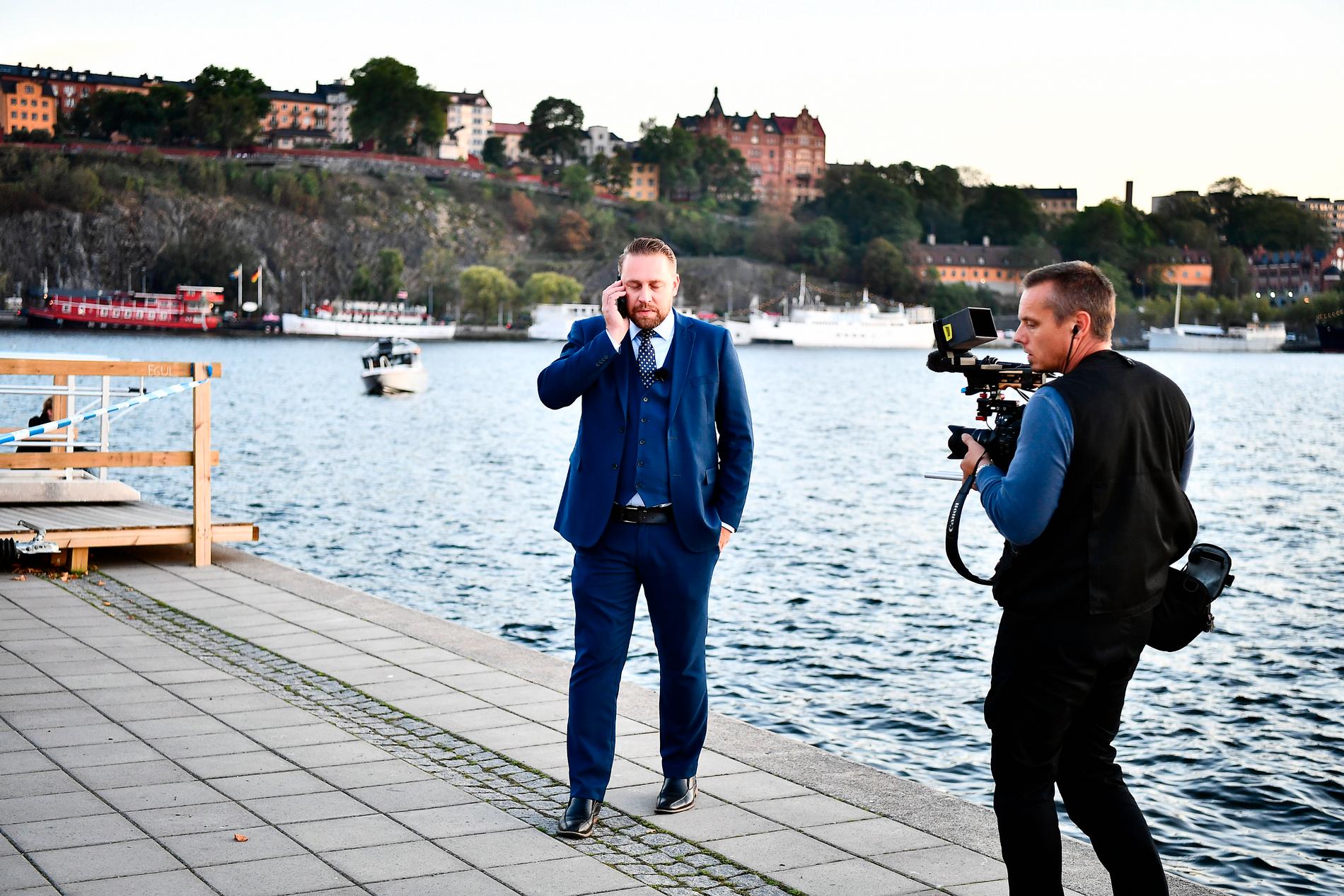 Mattias Karlsson (SD), stod en bit bort och talade i telefon under Åkessons tal på Riddarholmen.