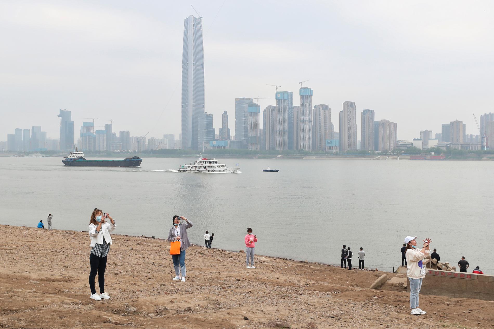 Invånare vid floden Yangtze i Wuhan i mars 2021.