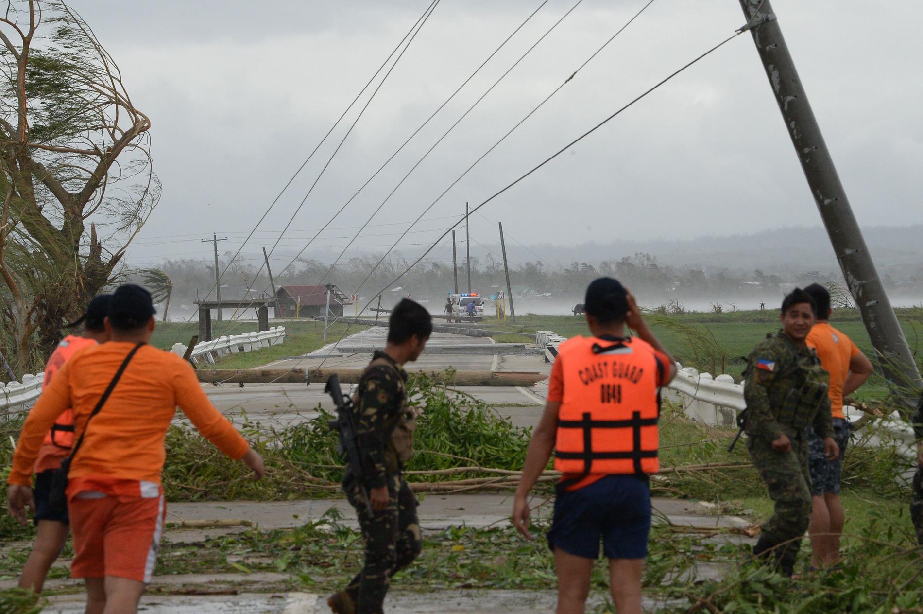 Räddningspersonal rensar vägar från bråte och fallna elstolpar i Baggao i Cagayan-provinsen.