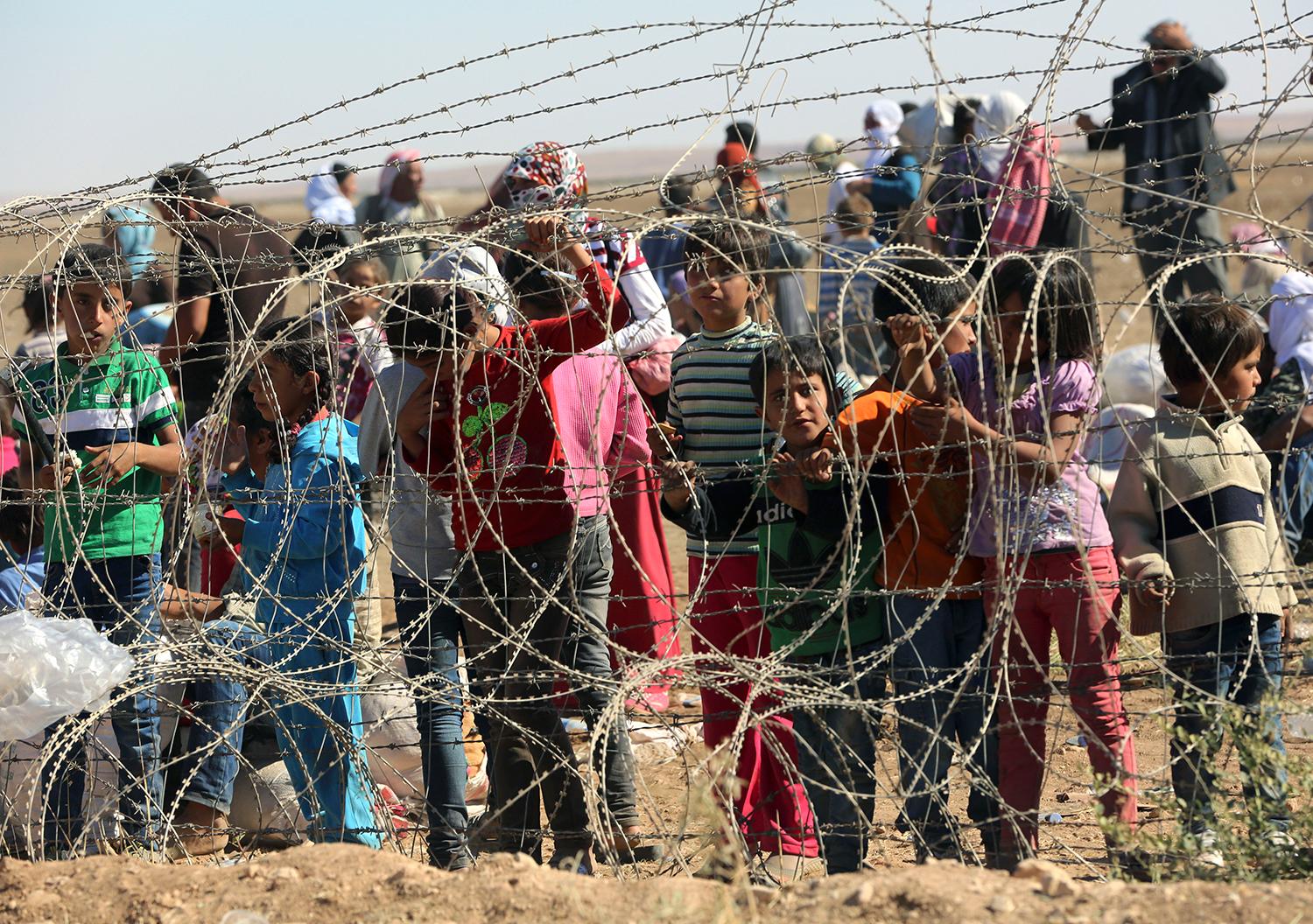 Hundratals syriska flyktingar väntar vid gränsövergången i Suruc, Turkiet.