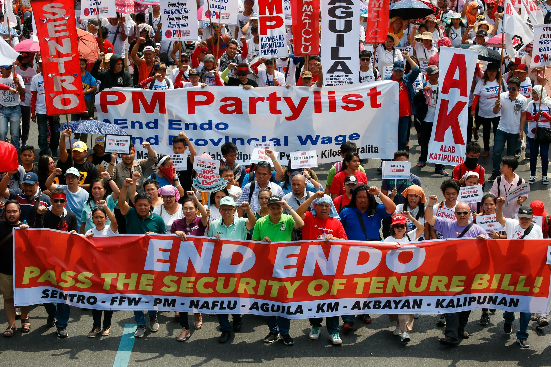 Tusentals marscherar mot presidentpalatset i Manila, Filippinerna för att kräva att regeringen sätter stopp för en särskild typ av tillfälliga anställningsformer. På banderollen står ENDO – "End of contract".