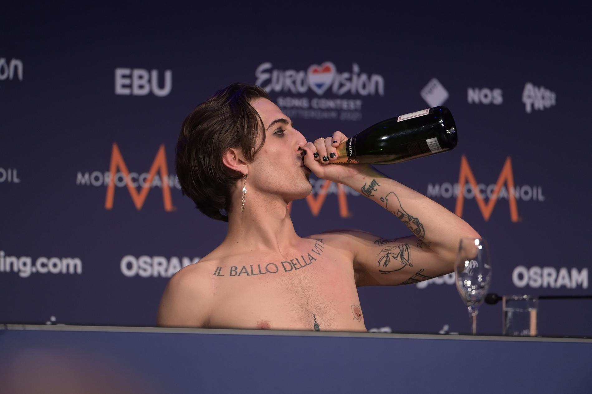 Måneskins Damiano David firar med att klunka champagne på presskonferensen.