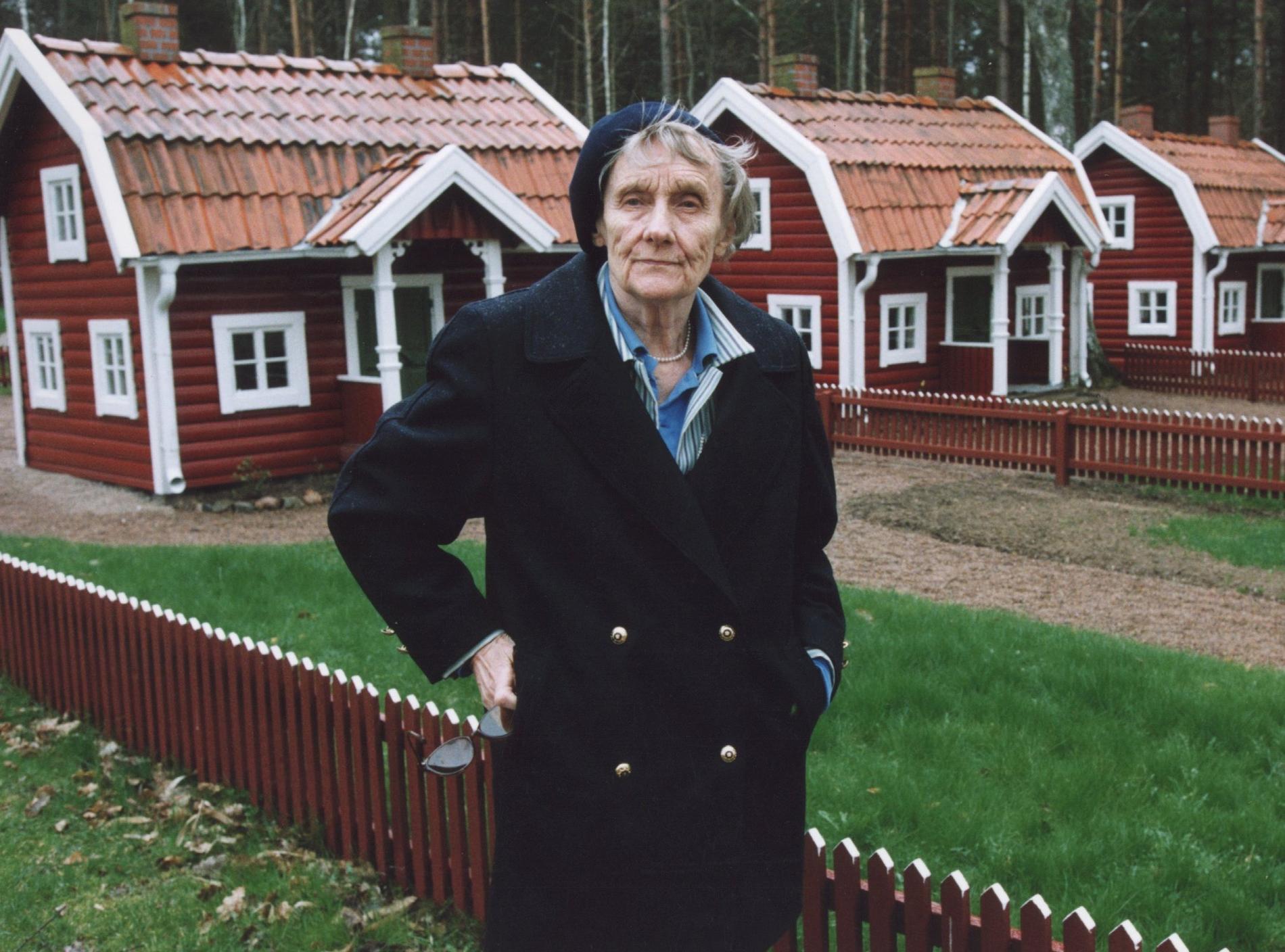 År 1999: Astrid Lindgren poserar framför röda stugor med vita knutar i Astrid Lindgrens Land i Vimmerby. Arkivbild.