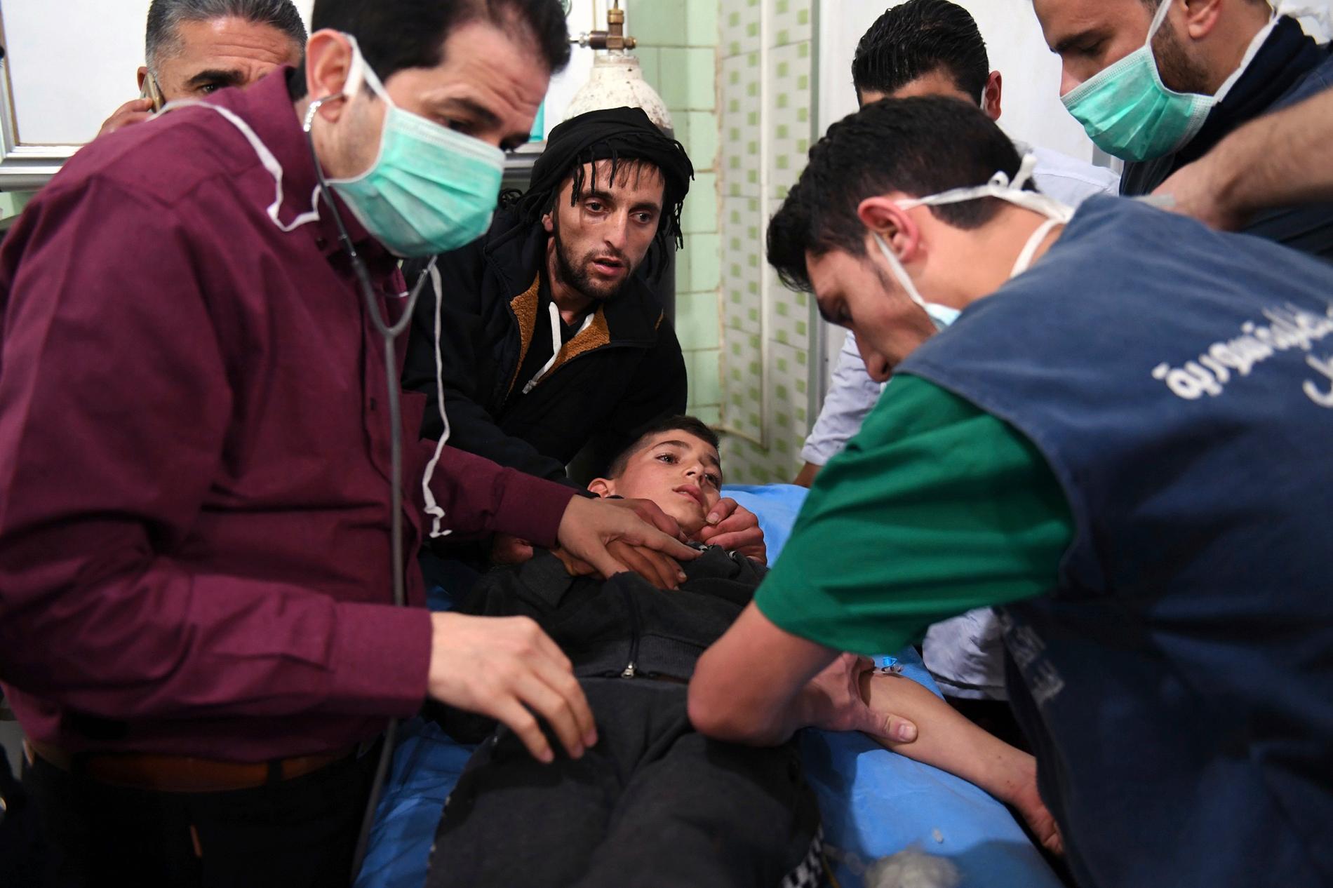 Sjukhuspersonal tar hand om en pojke som skadats i gasattacken i Aleppo.